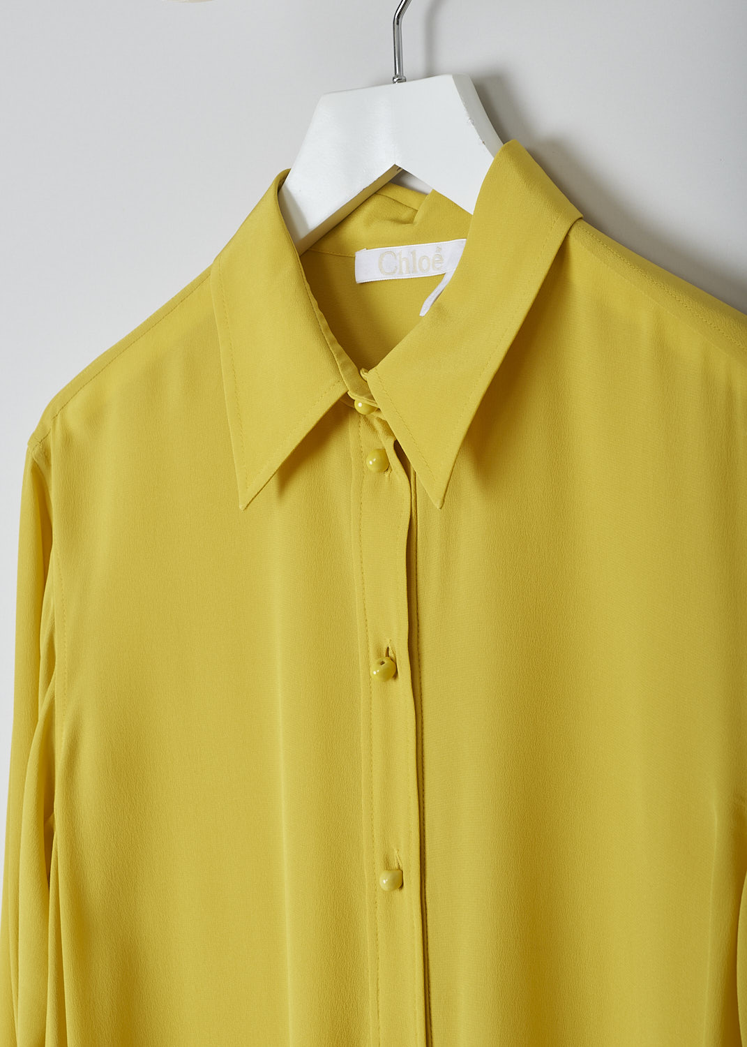 CHLOÃ‰, MUSTARD YELLOW DRESS, CHC22URO64004732_MUSTARD, Yellow, Detail, This mustard yellow shirt dress has a spread collar and a front button placket with ceramic buttons that reaches about halfway down. The long sleeves have cuffs with those same ceramic buttons. Slanted pockets are concealed in the side seam. The dress has a straight hemline with side slits. In the back, the dress has a centre box pleat. 
 
