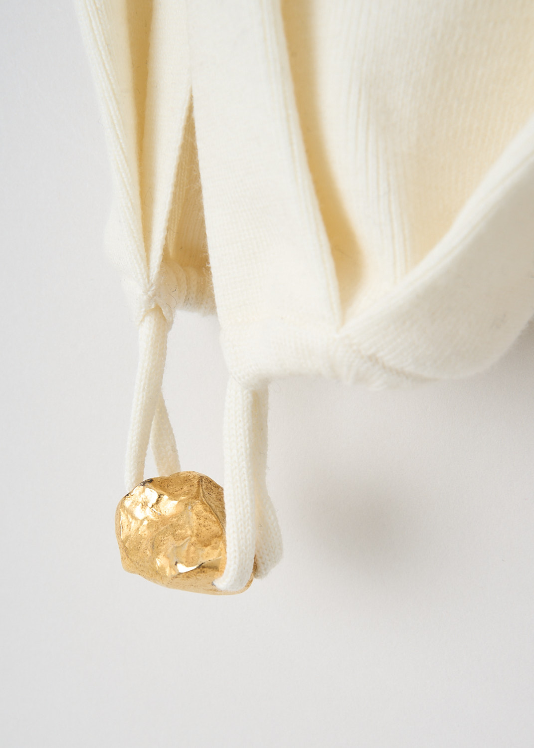 Chloé, Iconic Milk turtleneck sweater with gold sleeve detail, CHC23WMP24660107_ICONIC_MILK, White, Detail 1, This fitted turtleneck sweater in the color Iconic Milk features long sleeves with an open upper design that exposes the arm and shoulder, finished with a gold-tone embellishment at the cuff.
