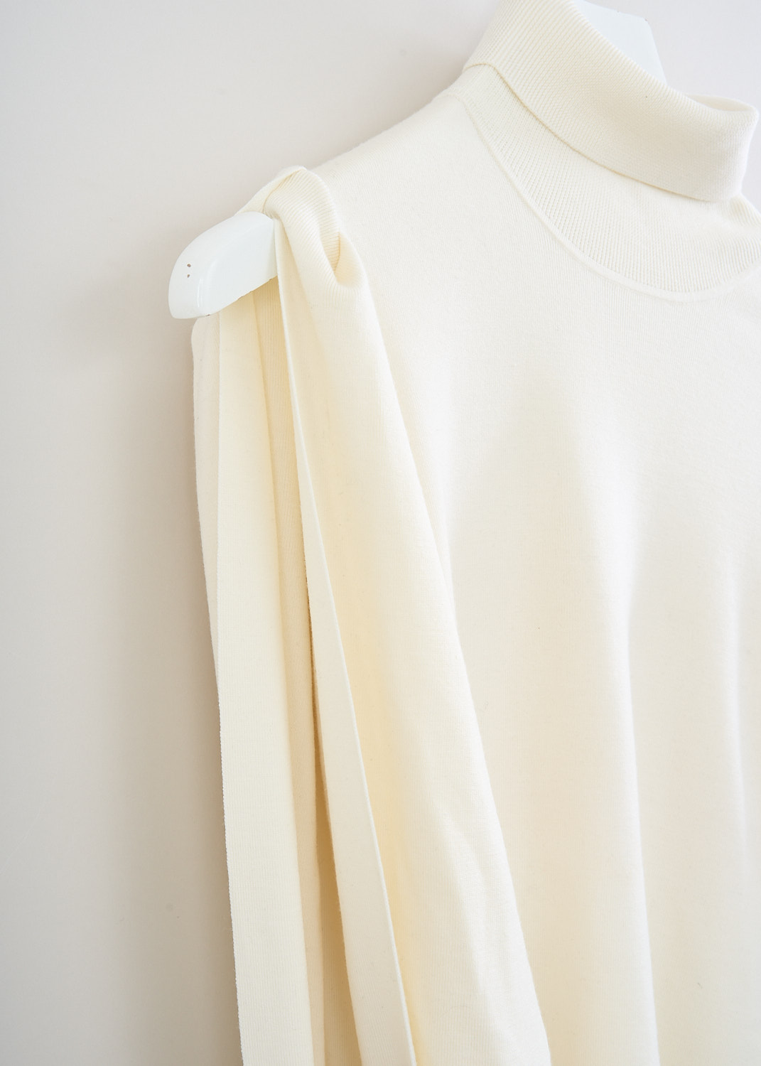 Chloé, Iconic Milk turtleneck sweater with gold sleeve detail, CHC23WMP24660107_ICONIC_MILK, White, Detail, This fitted turtleneck sweater in the color Iconic Milk features long sleeves with an open upper design that exposes the arm and shoulder, finished with a gold-tone embellishment at the cuff.

