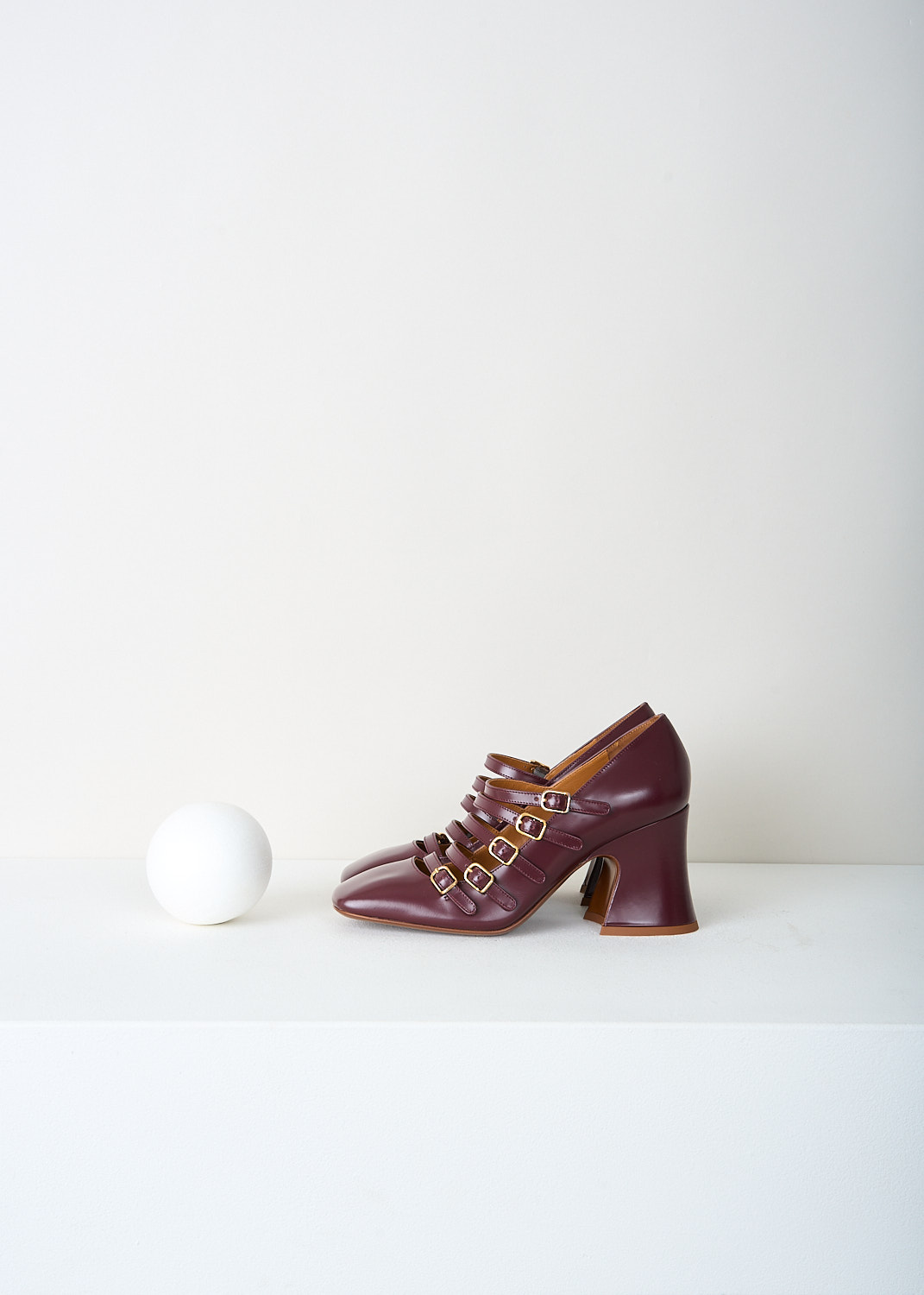 Side view of Chloé Janis pumps in burnt purple with curved 8 cm block heel and glossy leather finish.