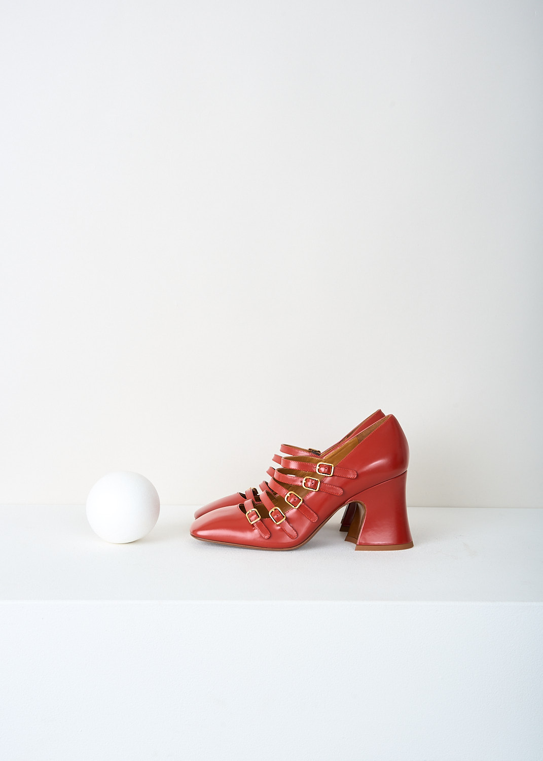 Side view of Chloé Janis pumps in earthy red with curved 8 cm block heel and glossy leather finish.