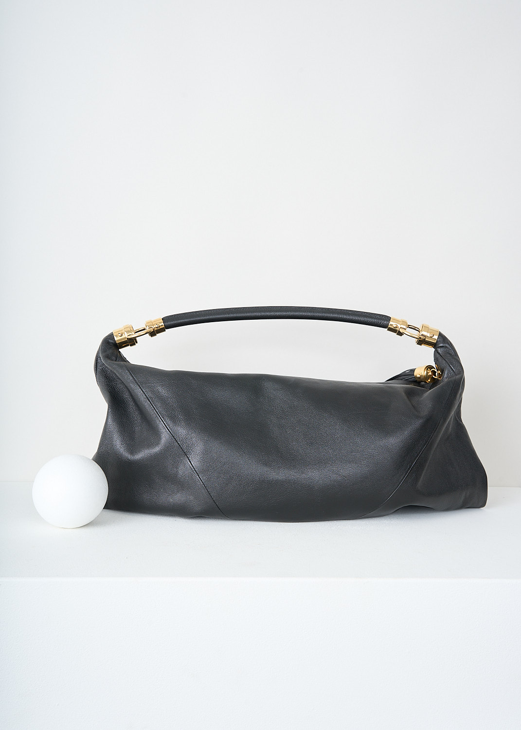 Chloé, Black foulard shoulder bag, CHC25SS446O37_001_BLACK, Black, Back, This grained black buffalo leather foulard shoulder bag has a supple silhouette. The bag has a single shoulder strap with an oversized tassel and the signature gold-tone Horse Medal hardware. The top-zip opens up to the main compartment what has a slip pocket.

