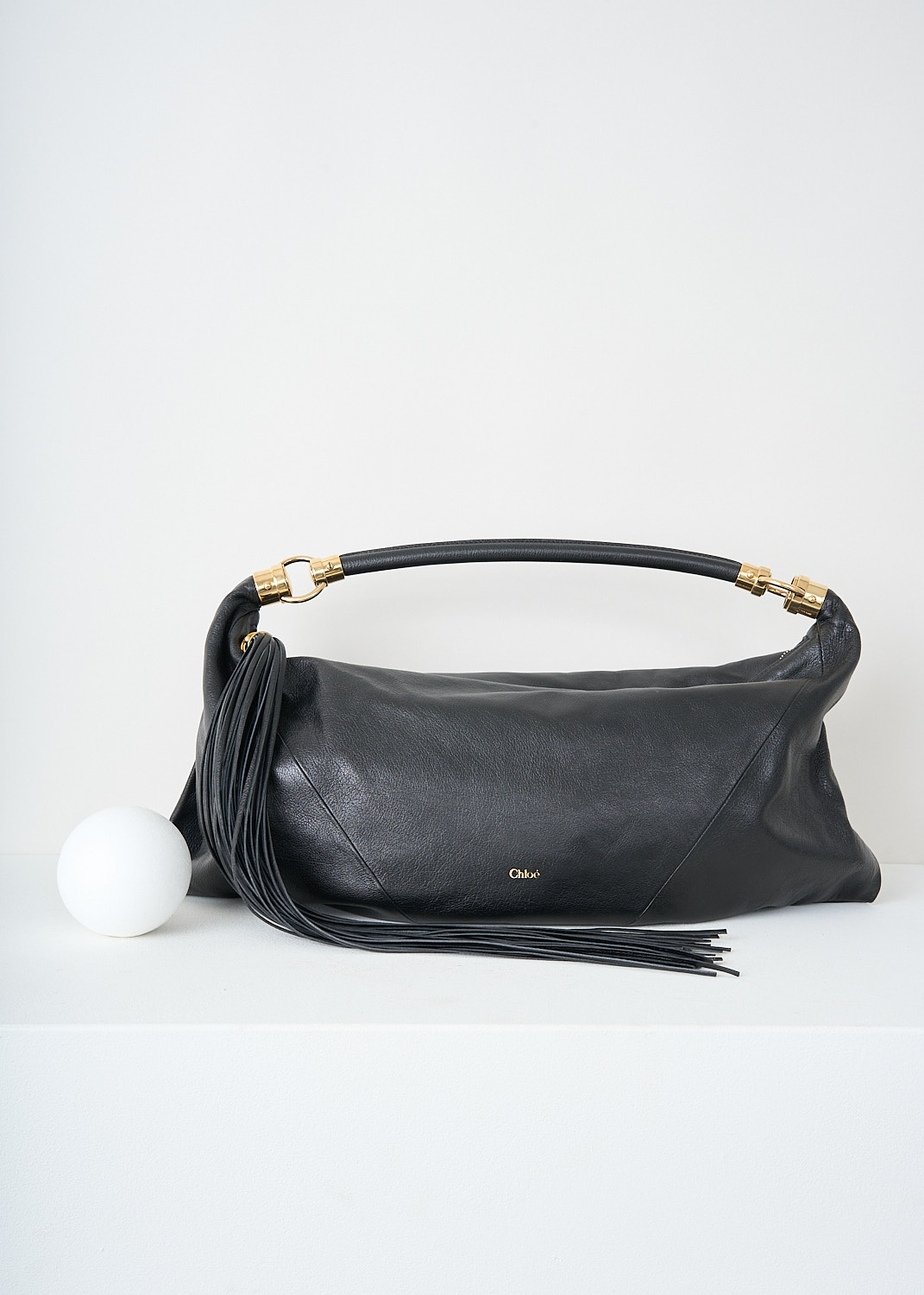 Chloé, Black foulard shoulder bag, CHC25SS446O37_001_BLACK, Black, Front, This grained black buffalo leather foulard shoulder bag has a supple silhouette. The bag has a single shoulder strap with an oversized tassel and the signature gold-tone Horse Medal hardware. The top-zip opens up to the main compartment what has a slip pocket.

