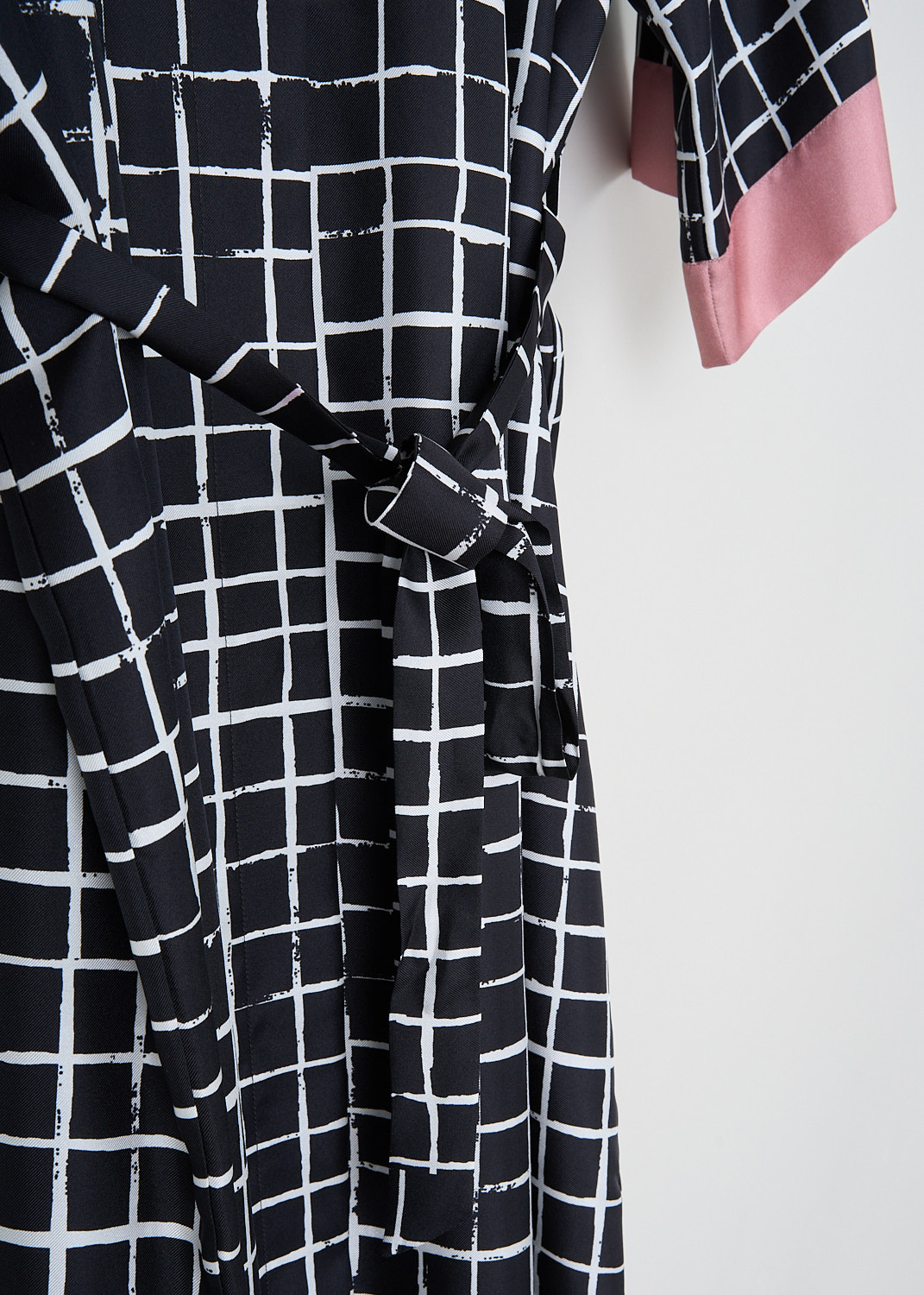Dries van Noten, Doralia dress with check print, DORALIA_9035_WW_DRESS_975_DESSIN_A, Black, Print, Pink, Detail, This silk Doralia shirt dress has a black-and-white check print. The dress has a spread collar and a concealed front button closure. On the front, the dress has a single breast pocket. Both the short sleeves and the straight hem have a contrasting pink trim. The dress comes with a matching fabric belt to cinch in the waist.
