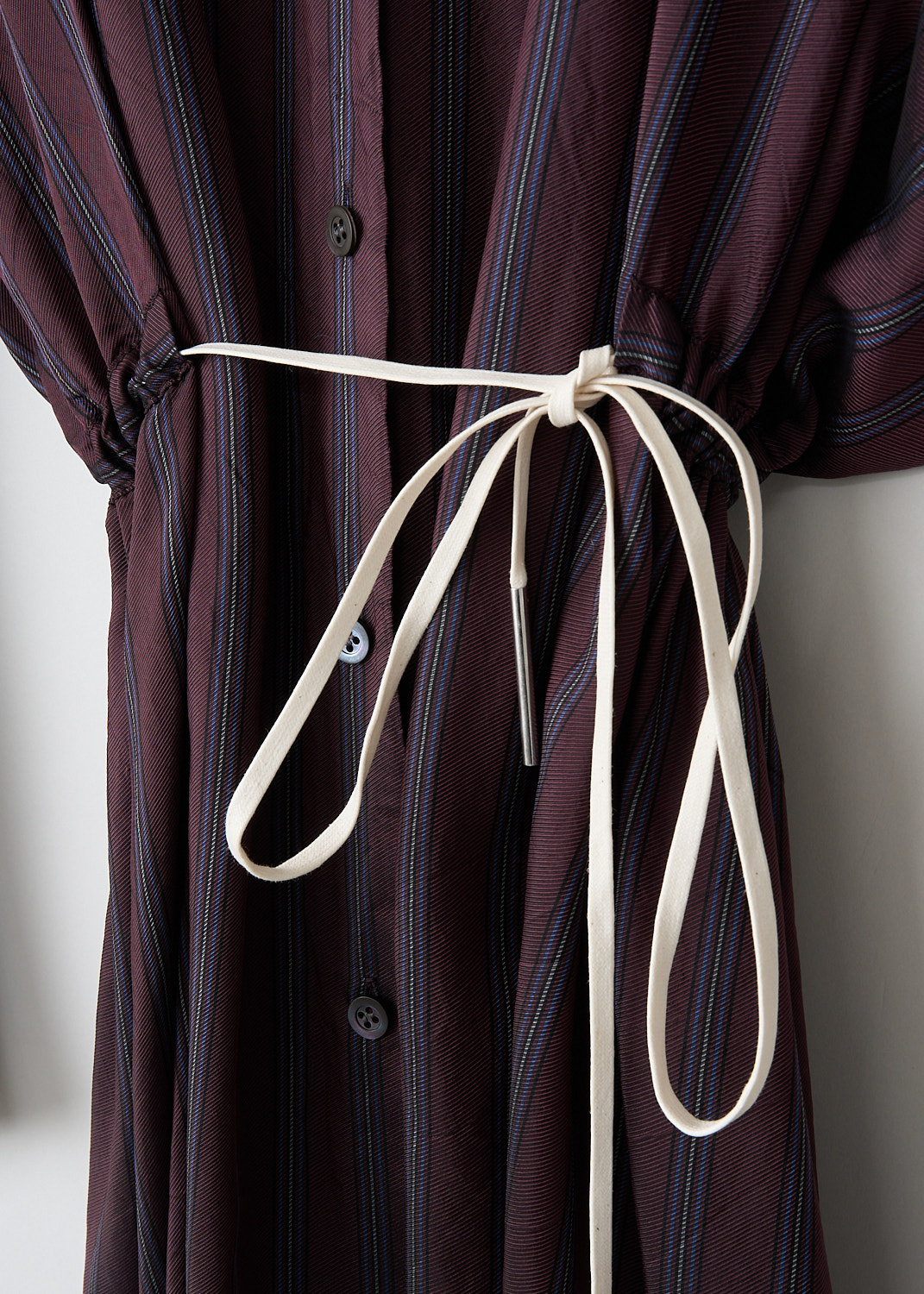 Dries van Noten, Dindia burgundy stripe dress, DINDIA_2267_WW_DRESS_358_BURGUNDY, Purple, Detail, This Dindia burgundy stripe shirt dress has a classic collar and a front button closure. The dress has wide dolman sleeves with buttoned cuffs. Along the waist, a contrasting white drawstring can be used to cinch in the waist.
