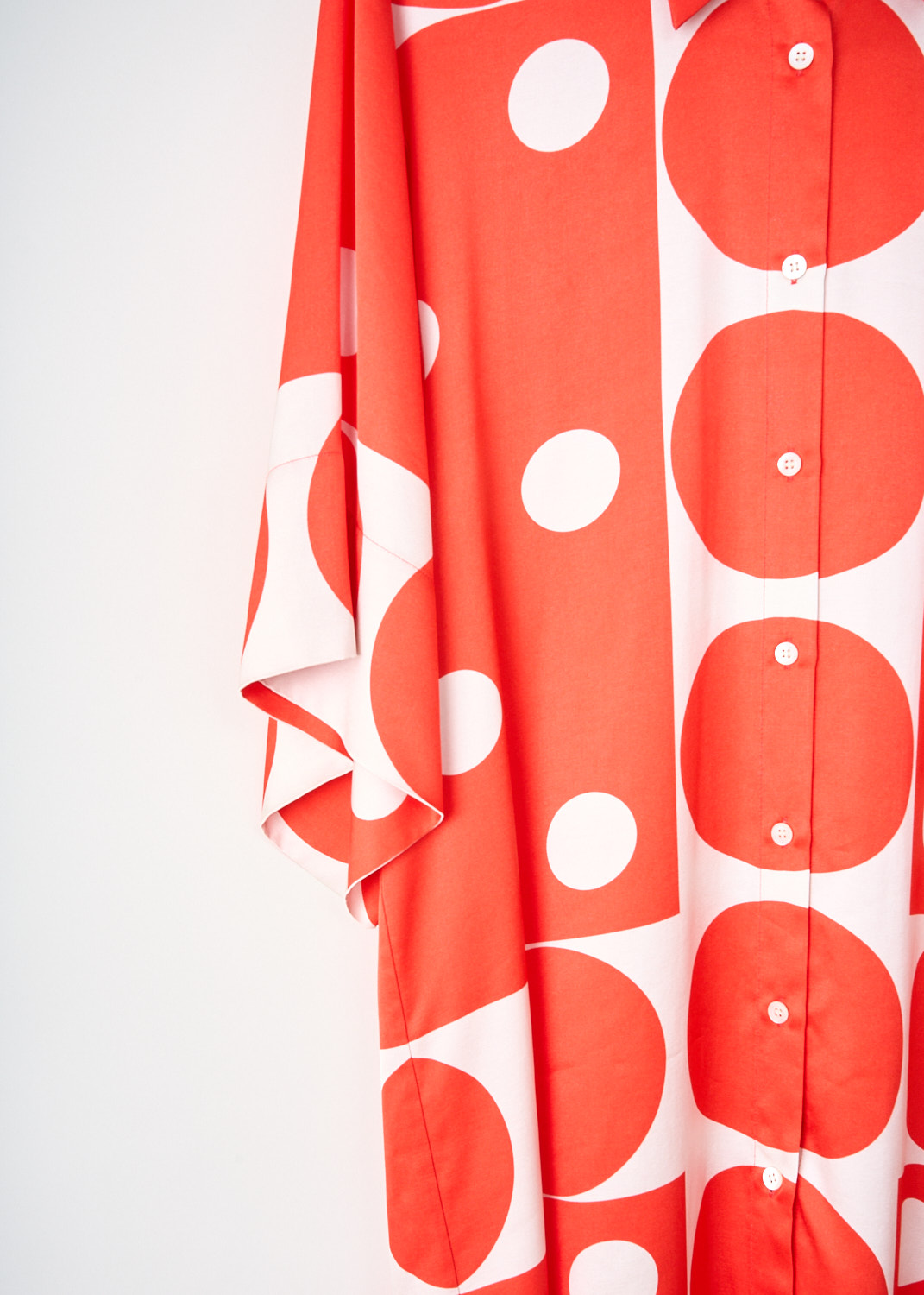 Close-up of the Dries van Noten Drea dress highlighting the red-and-white dotted satin, classic shirt collar and elegant button detailing – luxury designer sale item at Kiki’s Stocksale.