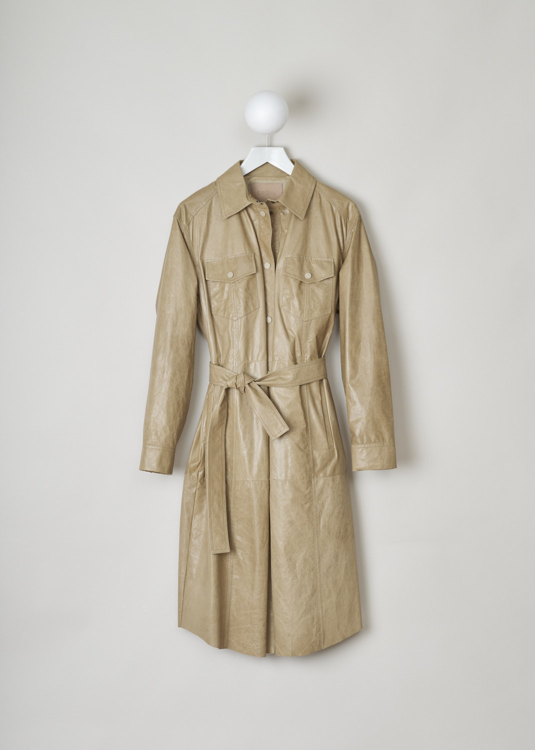 Drome, Beige leather shirt dress, DPD5565P_D1460_5038, Beige, Front, This beige shirt dress has an oversized silhouette. The dress features a pointed collar and a front press stud closure. The long sleeves have buttoned cuffs. On the front, the dress has two breast pockets. A matching fabric belt can be used to cinch in the waist.