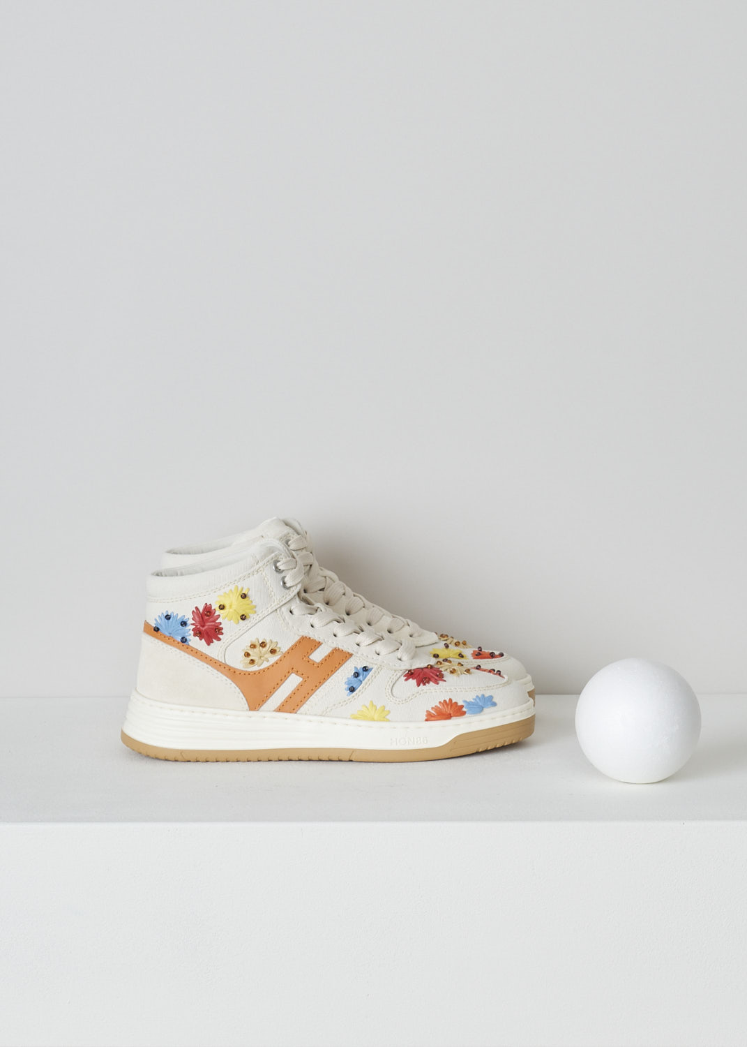HOGAN, BEIGE HIGH TOP SNEAKERS WITH EMBROIDERY, GYW6300EZ10S530TA3_S53,  White, Orange, Red, Side, These high top sneakers have a front lace-up fastening. The sneakers have a beige canvas base with multicolored embroidered flowers. These flowers are further decorated with beads. On the sides, the brand's H-logo has been incorporated in the design in orange. These sneakers have  thick rubber soles. 

