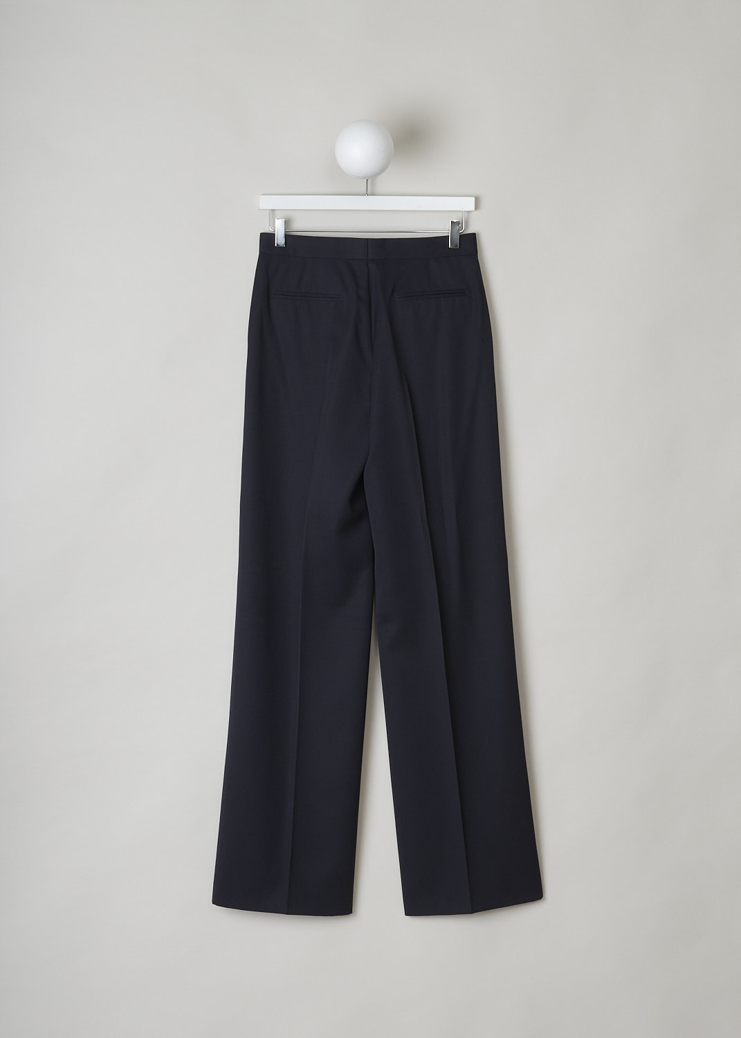 JIL SANDER, MIDNIGHT BLUE WIDE-LEG PANTS, JSPN302220_WN200300_402, Blue, Back, These navy blue wool pants have a narrow waistband with, attached in the front, a narrow belt-like band with a concealed button closure. These pants have a concealed clasp and button closure. The wide pant legs have pressed creases. These pants have slanted pockets in the front and welt pockets in the back. 
