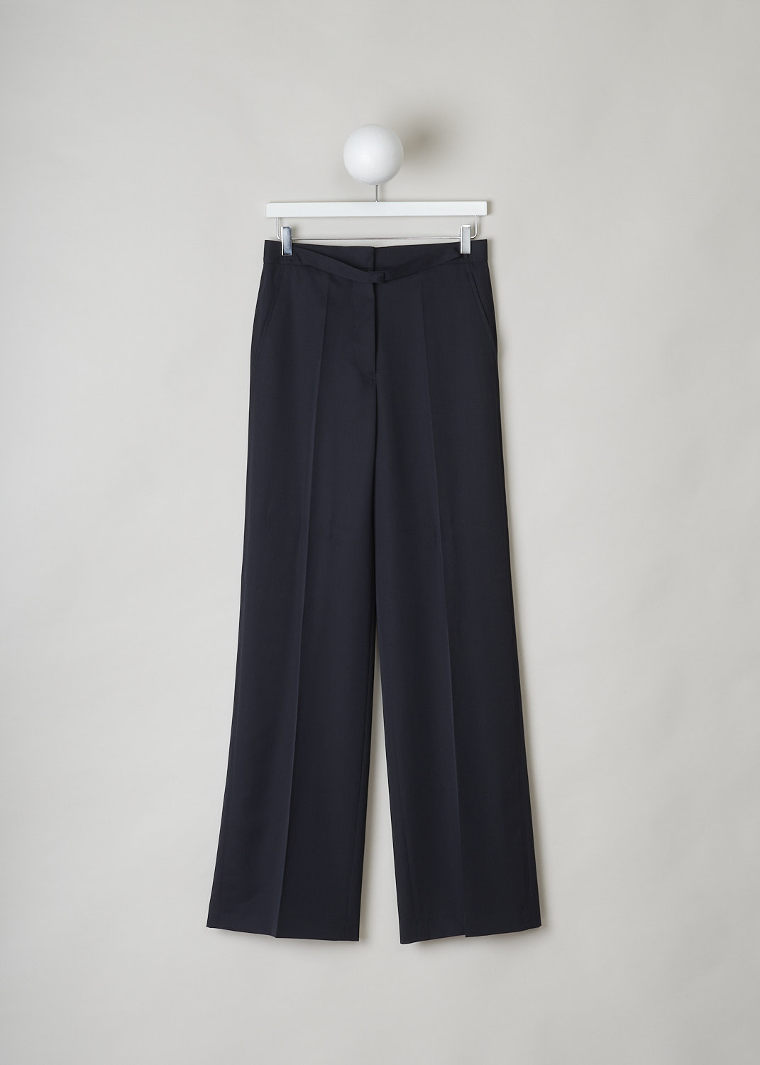 JIL SANDER, MIDNIGHT BLUE WIDE-LEG PANTS, JSPN302220_WN200300_402, Blue, Front, These navy blue wool pants have a narrow waistband with, attached in the front, a narrow belt-like band with a concealed button closure. These pants have a concealed clasp and button closure. The wide pant legs have pressed creases. These pants have slanted pockets in the front and welt pockets in the back. 
