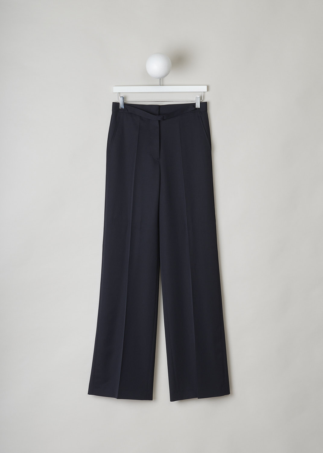 JIL SANDER, MIDNIGHT BLUE WIDE-LEG PANTS, JSPN302220_WN200300_402, Blue, Front, These navy blue wool pants have a narrow waistband with, attached in the front, a narrow belt-like band with a concealed button closure. These pants have a concealed clasp and button closure. The wide pant legs have pressed creases. These pants have slanted pockets in the front and welt pockets in the back. 
