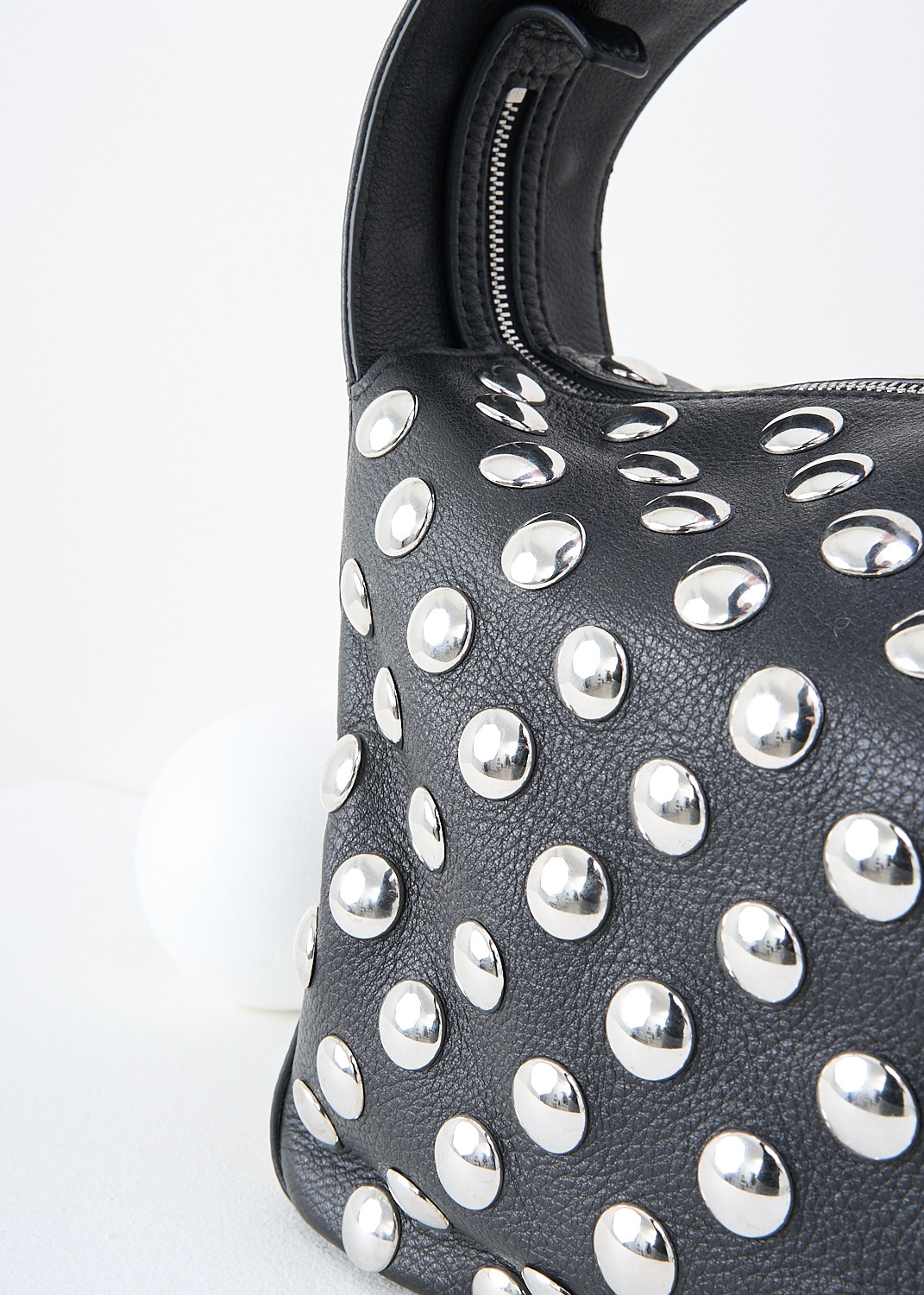Khaite, Black leather Elena shoulder bag with silver studs, ELENA_SHOULDER_BAG_H2025_798_200_BLACK, Detail, This black leather Elena shoulder bag with silver studs has a single broad shoulder strap. The boxy bag has a top-zip closure that opens up to its spacious compartment with, to one side, a slip pocket.

