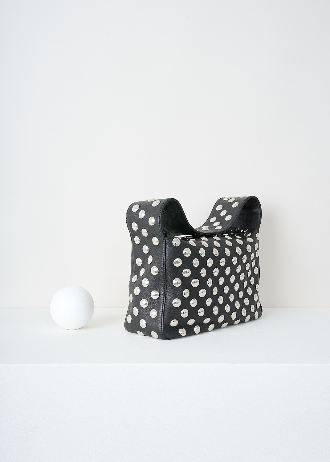 Khaite, Black leather Elena shoulder bag with silver studs, ELENA_SHOULDER_BAG_H2025_798_200_BLACK, Side, This black leather Elena shoulder bag with silver studs has a single broad shoulder strap. The boxy bag has a top-zip closure that opens up to its spacious compartment with, to one side, a slip pocket.

