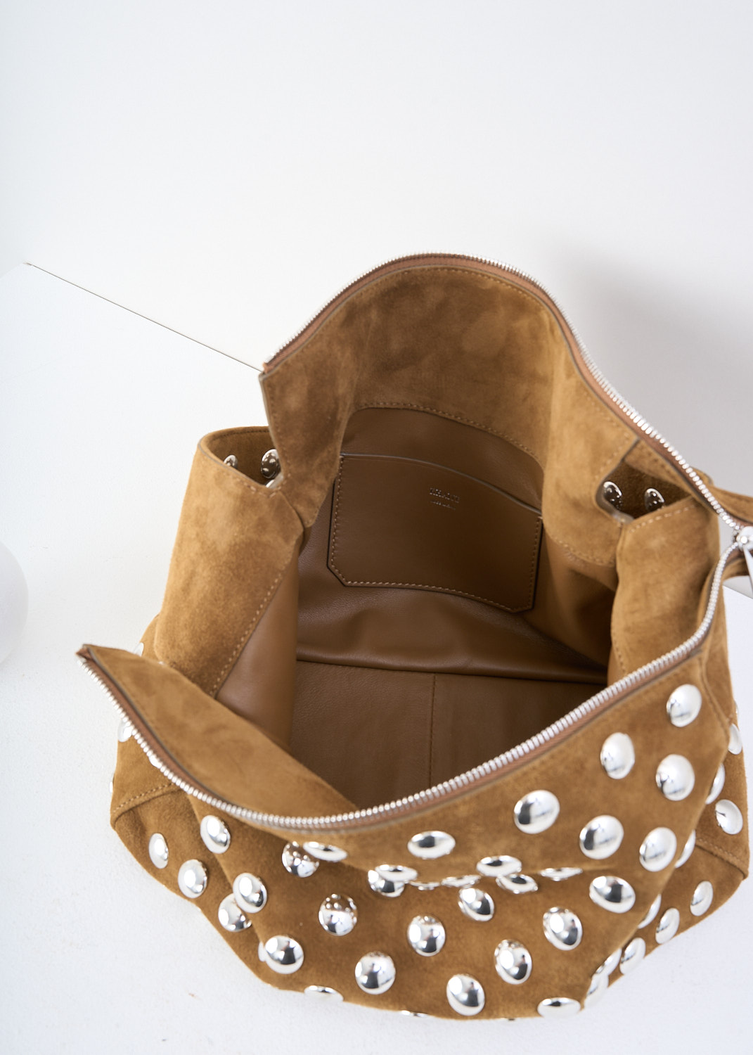 Khaite, Elena shoulder bag with silver studs in Mud, 
ELENA_SHOULDER_BAG_H2025_849_737_MUD, Brown, Detail 1, This Elena shoulder bag with silver studs in the color Mud has a single broad shoulder strap. The boxy bag has a top-zip closure that opens up to its spacious compartment with, to one side, a slip pocket. 