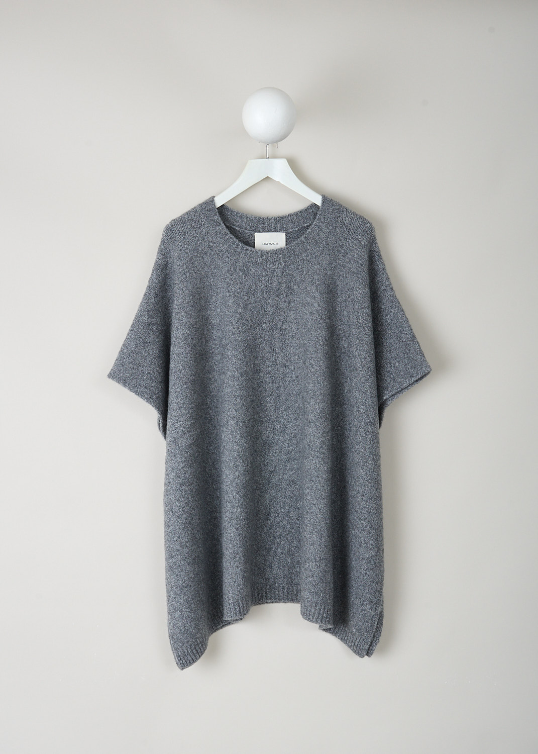 Lisa Yang Minn cape in Speckled Graphite bouclé with round neckline and wide, relaxed silhouette, crafted from an 82% cashmere and 18% nylon blend, luxury designer knitwear at Kiki’s Stocksale Maastricht