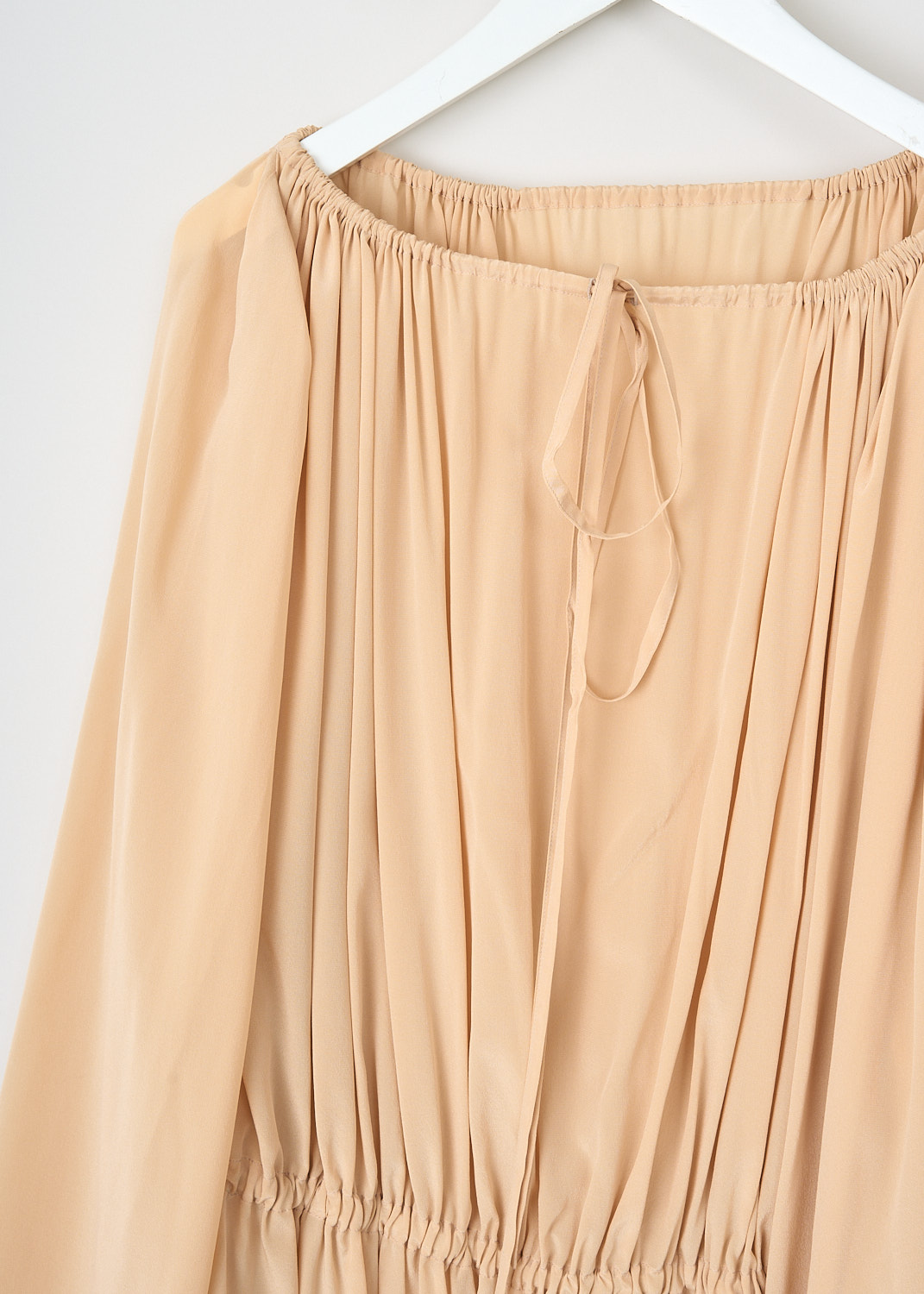 Marie, Adam-Leenardt Beach cabin top in Nude, BEACH_CABINE_TOP_A4008_1024_NUDE, Beige, Detail, This Beach cabin top in Nude has a round neckline with a drawstring closure in the back that can be used to cinch in the neckline. The top has long bell sleeves and a gathered hem with a flowy finish.
