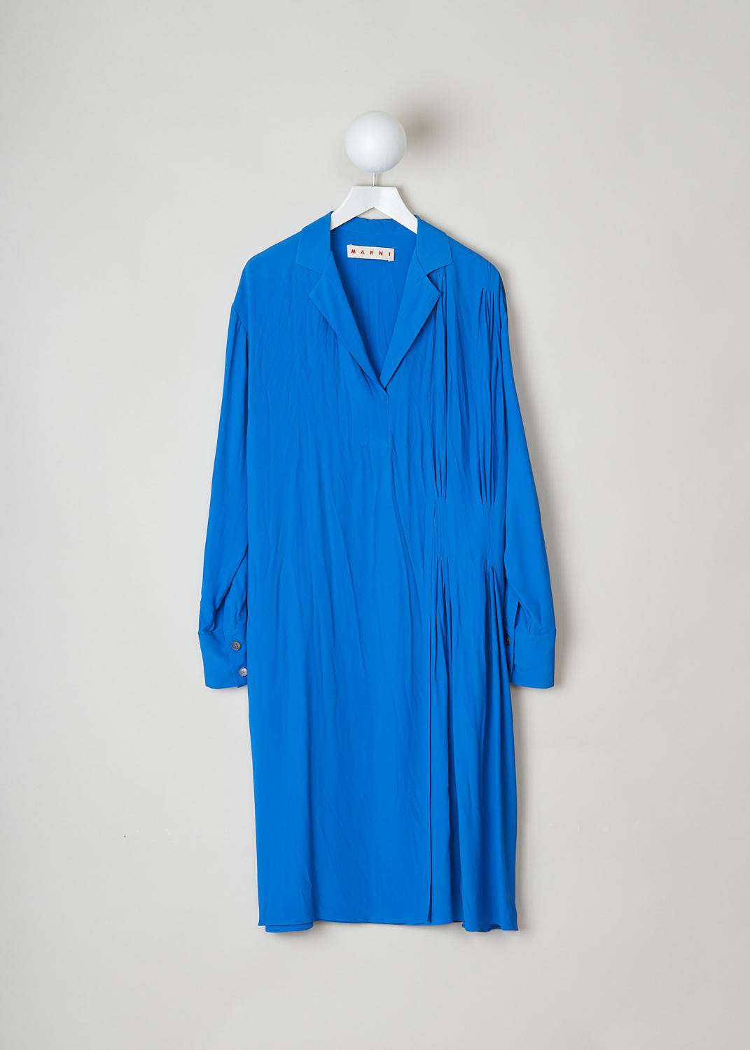 MARNI, ROYAL BLUE ASYMMETRICAL COLLAR DRESS, ABMA0171A0_TA089_00B57, Blue, Front, The royal blue dress features a notched lapel and a split neckline. The long sleeves have buttoned cuffs. The dress is mid-length and has a wider fit. A pleated detail can be found on one side and the dress has a layered skirt. 
