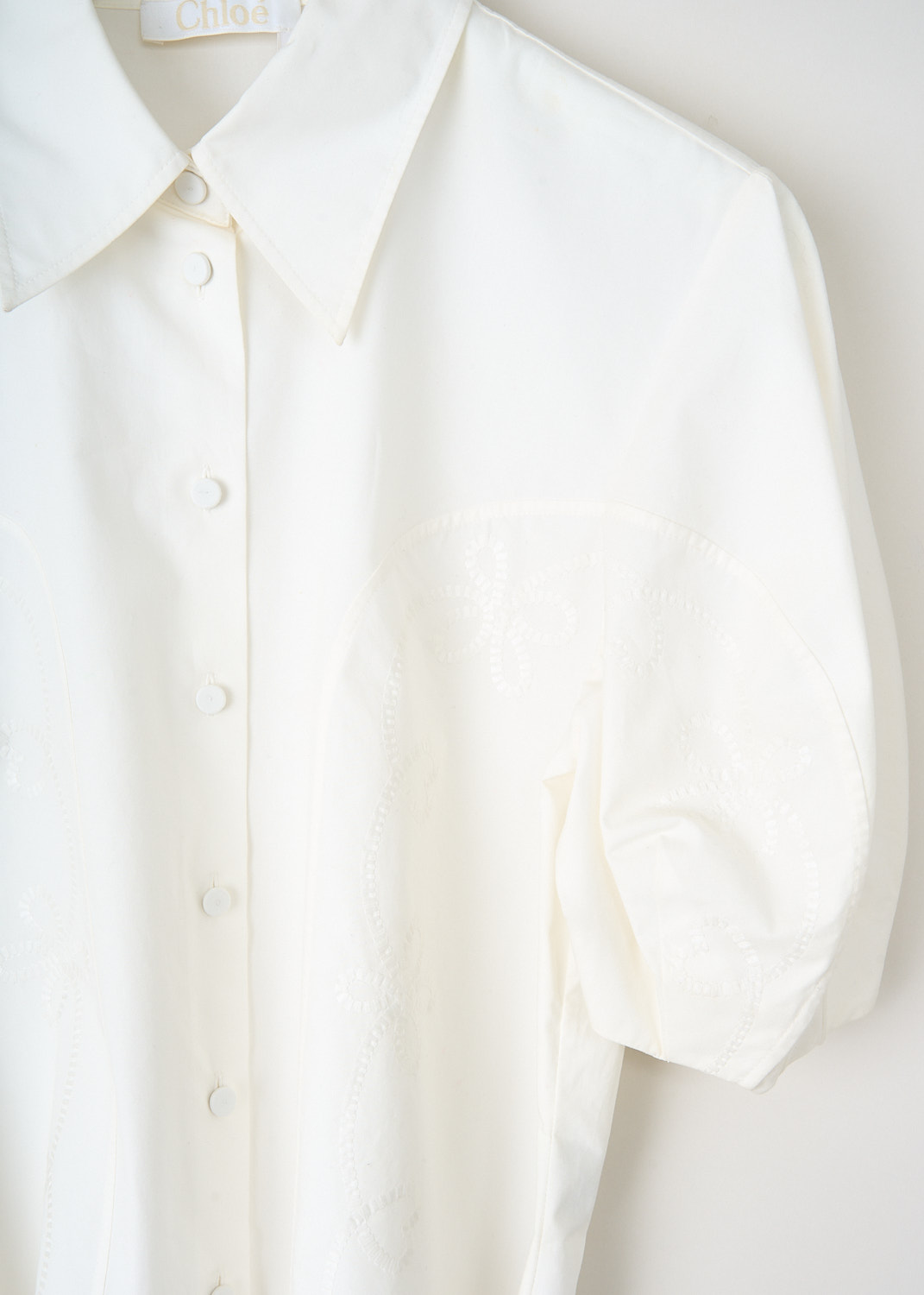 Close-up of Chloé blouse showing broderie anglaise embroidery, collar detail and button closure.