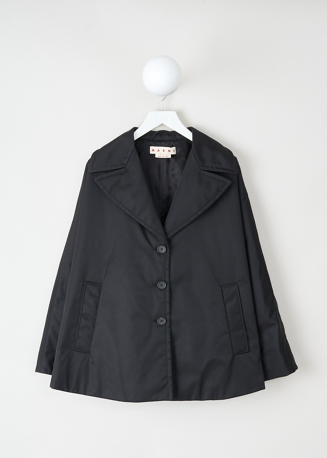 Marni, Twill cape coat in black, CPMA0251SW_UTN923_00N99, Black, Front, This short black twill-weave cape coat has a notched lapel and a front button closure. The coat has long sleeves and a high-low hemline.  On the front, the coat has two slanted pockets. The coat has a loose fit. The coat is fully lined.
