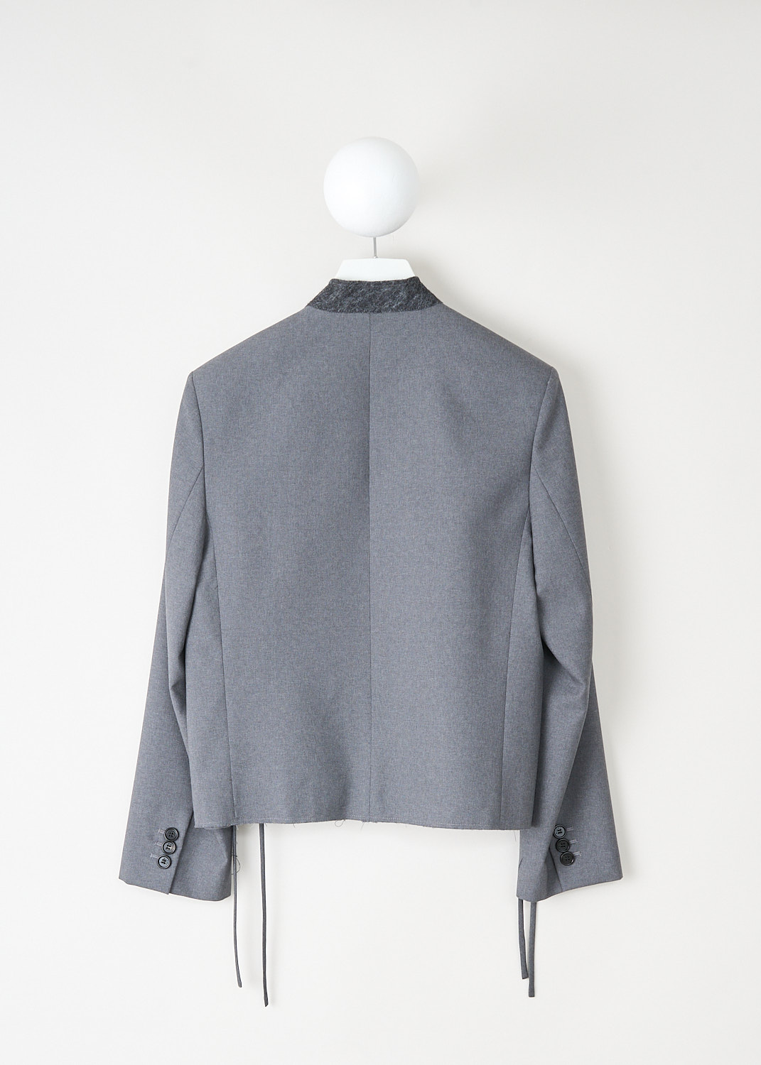 Back view of the grey wool jacket with raw hem and long sleeves by Marni, available at designer boutique Kiki's Stocksale in Maastricht.