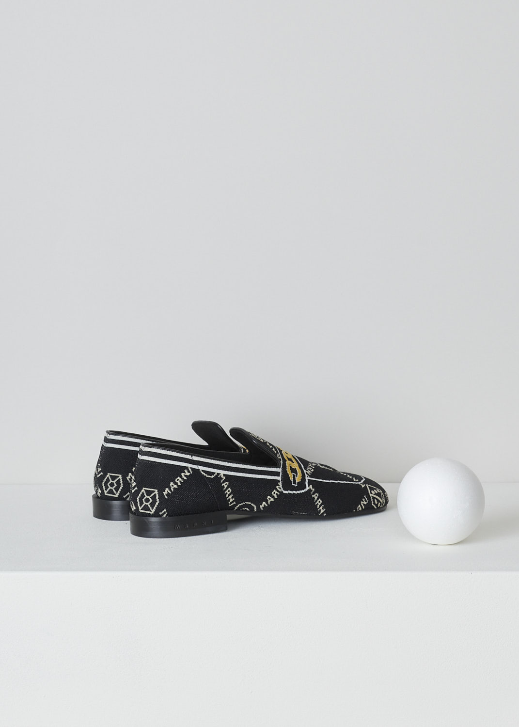 MARNI, BLACK TROMPE L'OEIL JACQUARD MOCCASINS, MOMS003601_P4601_Z2Q23, Black, Back, These black knitted moccasins have a trompe l'oeil image woven into them which depicts a gold chain across the vamp. The brand's logo is woven into them throughout the shoe in white. These moccasins have a round toe and flat rubber sole with a small heel. 
