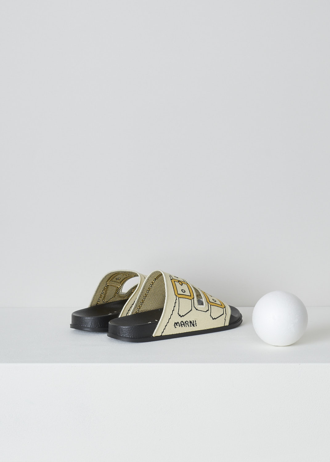 MARNIm OFF-WHITE TROMPE L'OEIL JACQUARD SLIDES, SAMS015802_P4547_ZO202, White, Back, These off-white knitted slides have a trompe l'oeil image woven into the straps across the vamp. The image depicts straps with gold buckles. The brand's logo is woven into the side. These slip-on slides have a round open toe. The slides have a molded footbed and a flat rubber sole. 