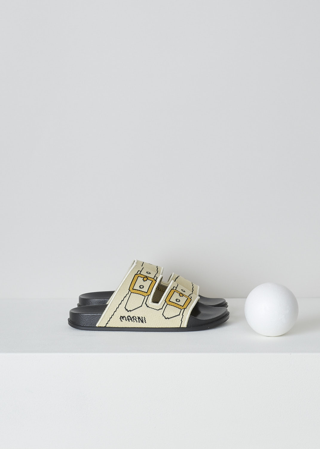 MARNIm OFF-WHITE TROMPE L'OEIL JACQUARD SLIDES, SAMS015802_P4547_ZO202, White, Side, These off-white knitted slides have a trompe l'oeil image woven into the straps across the vamp. The image depicts straps with gold buckles. The brand's logo is woven into the side. These slip-on slides have a round open toe. The slides have a molded footbed and a flat rubber sole. 