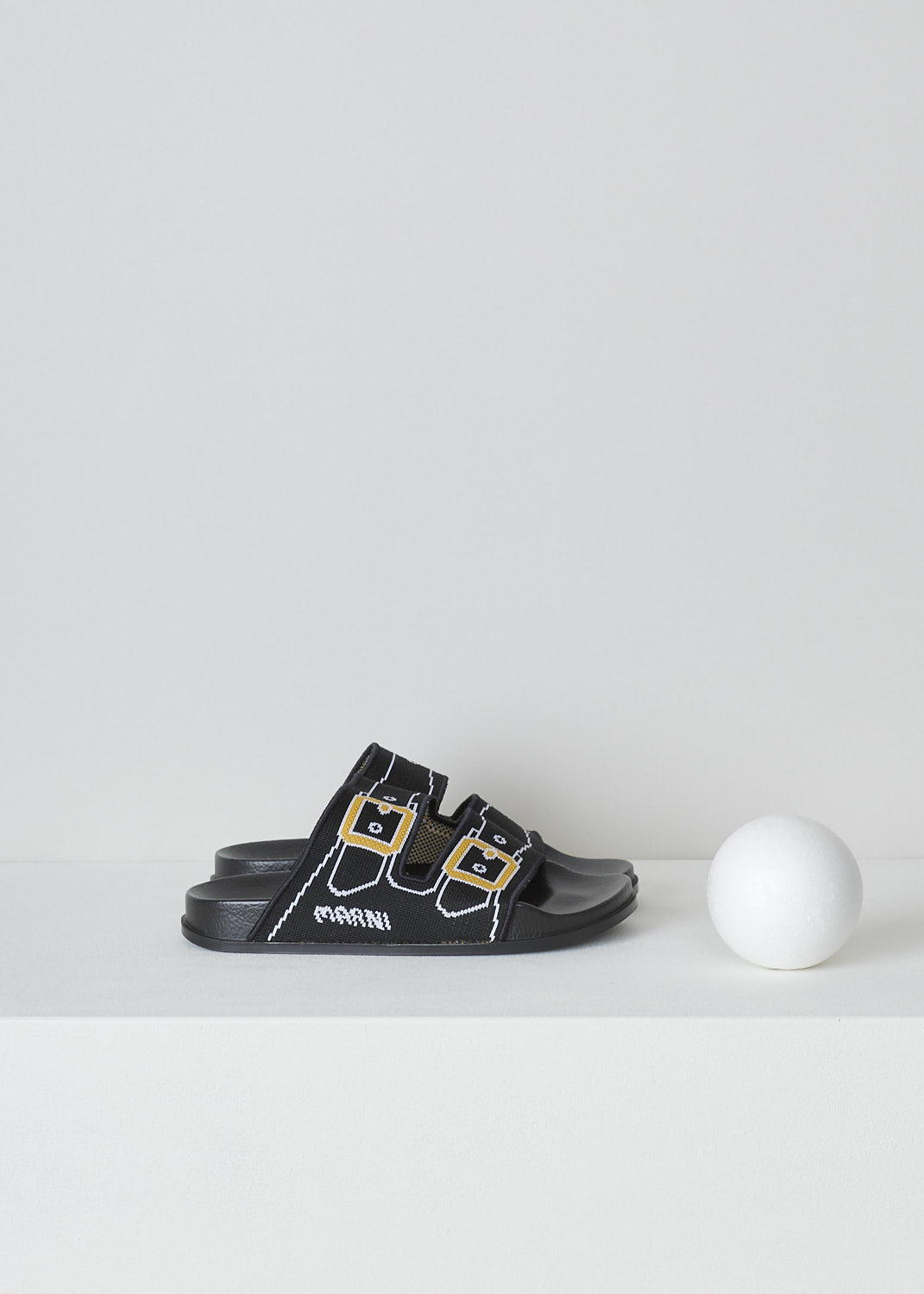 MARNI, BLACK TROMPE L'OEIL JACQUARD SLIDES, SAMS015802_P4547_ZO137, Black, Side, These black knitted slides have a trompe l'oeil image woven into the straps across the vamp. The image depicts straps with gold buckles. The brand's logo is woven into the side. These slip-on slides have a round open toe. The slides have a molded footbed and a flat rubber sole. 
 
 
