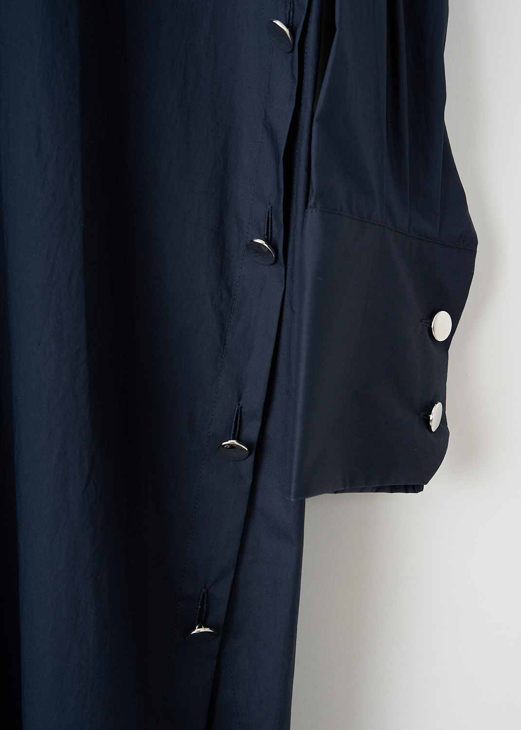 Plan C, Navy blue shirt dress with button detailing, ABCAF16K0_00TC063_00B97, Blue, Detail, This navy blue shirt dress has a spread collar and a partial button placket down the front. The dress has long sleeves with buttoned cuffs.  The buttons along the side seams can be used to preference. Silver-tone buttons have been used throughout the dress. 
