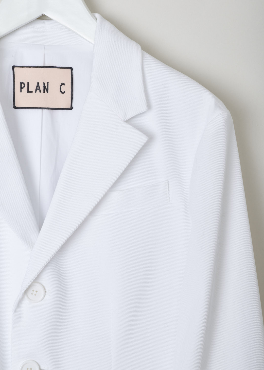 Plan C, White cotton blazer, GICAA55BF0_TC042_00W03, white, detail, White blazer made of Plan C, White cotton jacket, GICAA55BF0_TC042_00W03, White, Detail 1, This white cotton jacket has a notched lapel and a front button closure. The long sleeves have buttoned cuffs. The jacket has a single breast pocket, two flap pockets and a ticket pocket. In the back, the jacket has a centre vent.  
 and has long cuffed sleeves with four buttons. The notched lapel sits above the fastening option, which has three buttons. Further adorning the front are three flap pockets and a single chest pocket. On the back this model comes with a center split. 