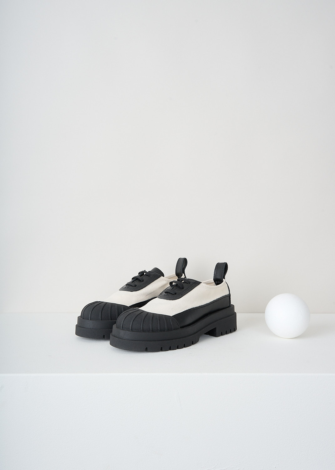 Plan C, Canvas sneakers with contrasting sole, PC40030A_17030, White, Black, Front, These canvas sneakers have a round toe and a leather tongue and a leather lace placket with black laces. These shoes have a contrasting rubber toe cap that extends in a strip along the chunky sole to the heel and up to the pull tab.
