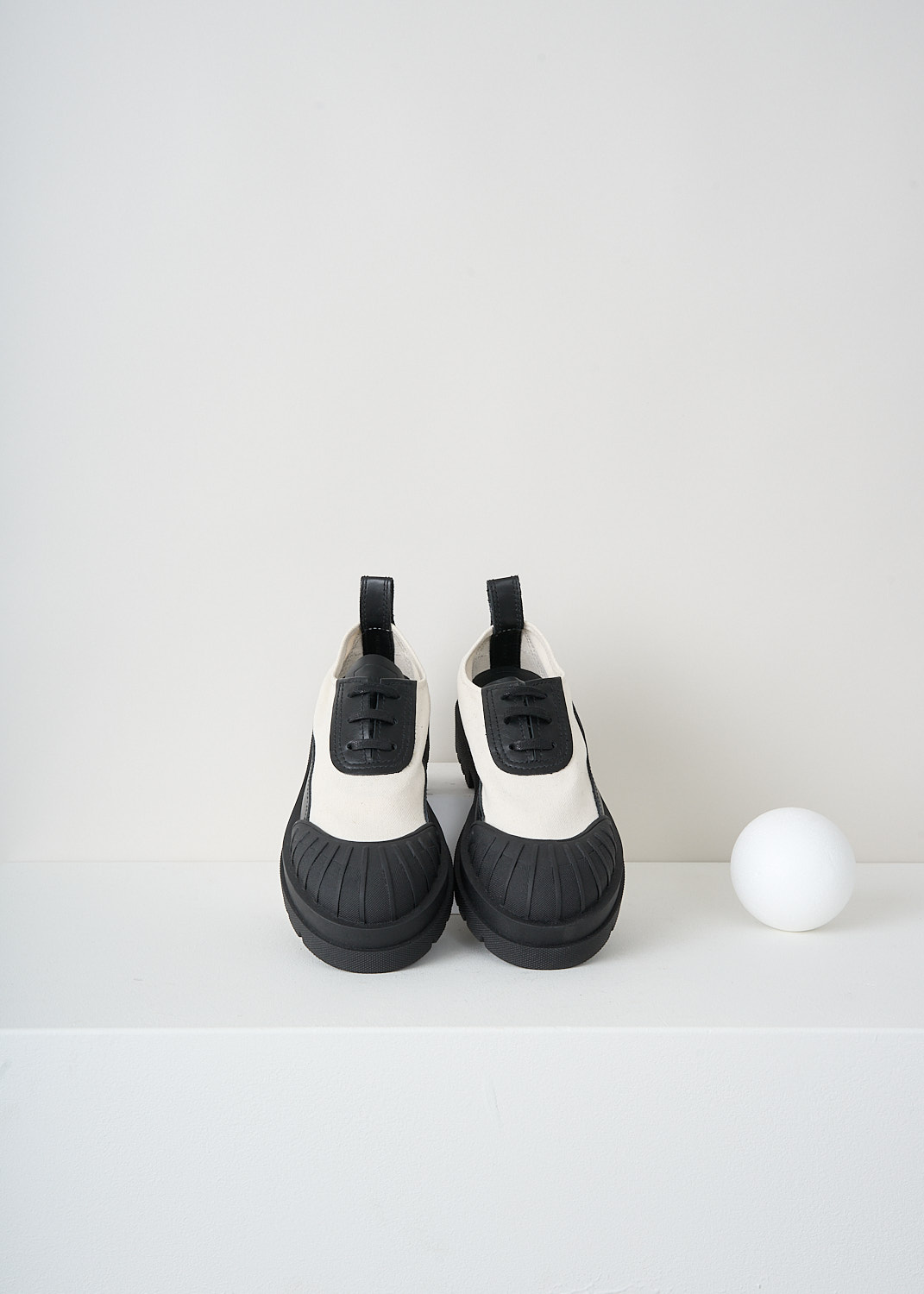 Plan C, Canvas sneakers with contrasting sole, PC40030A_17030, White, Black, Top, These canvas sneakers have a round toe and a leather tongue and a leather lace placket with black laces. These shoes have a contrasting rubber toe cap that extends in a strip along the chunky sole to the heel and up to the pull tab.
