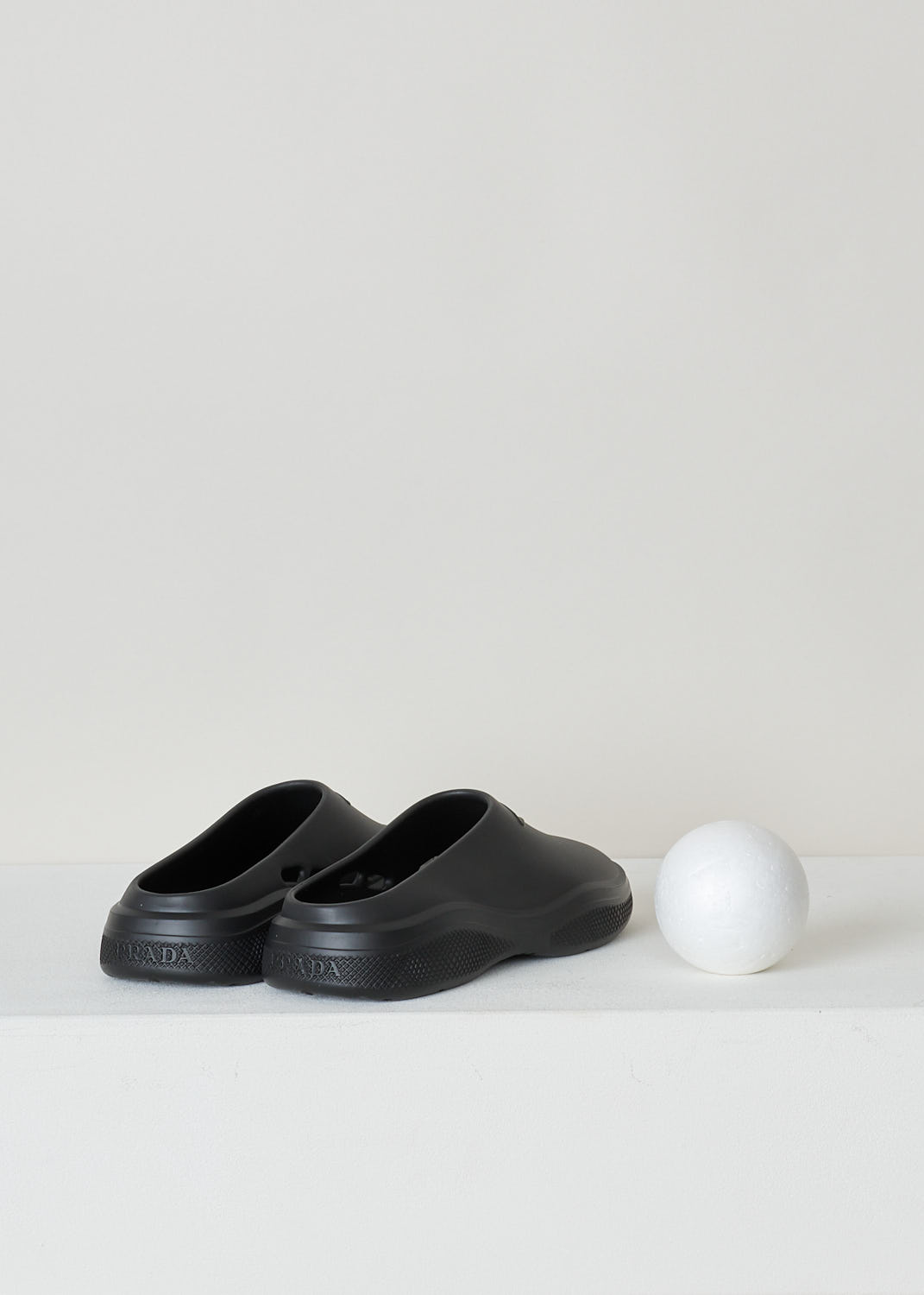 PRADA, BLACK SLIDES, 1S811M_3LKD_F0002_9_99_F_025_CALZATURE_DONNA_MELLOW_NERO, Black, Back, These black slip-on style slides have a round toe with an embossed logo on the front. These slides have chunky soles. 
