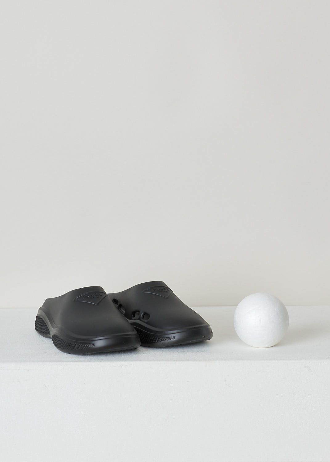 PRADA, BLACK SLIDES, 1S811M_3LKD_F0002_9_99_F_025_CALZATURE_DONNA_MELLOW_NERO, Black, Front, These black slip-on style slides have a round toe with an embossed logo on the front. These slides have chunky soles. 
