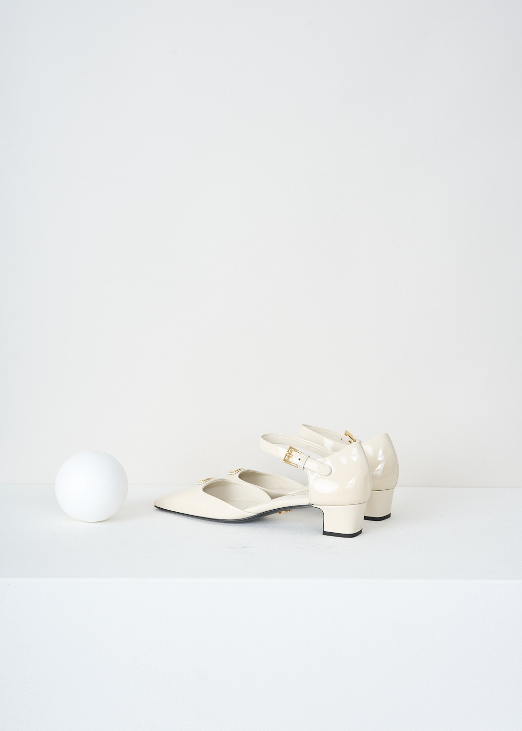 Prada, Patent leather off-white pumps with ankle strap, 069_VERNICE_1I601N_F0304_AVORIO, White, Back, These off-white patent leather Mary Jane pumps feature a squared-off toe with the brand’s signature triangle logo, a small block heel, and an ankle strap secured with a gold-tone buckle.

heel height: 3.5 cm / 1.3 in.
