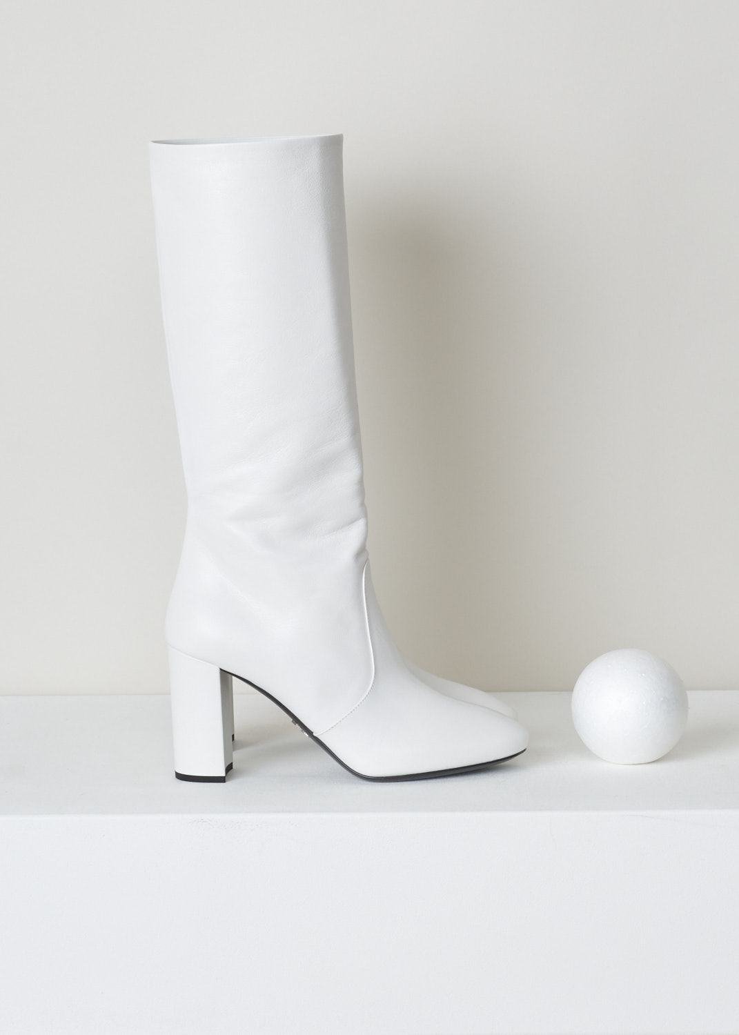 PRADA, WHITE HEELED BOOTS, MADRAS_1W684L_034_BIANCO, White, Side, White leather boots with a heel. These boots hit right below the knee. The toe of these shoes is almond shaped. The closure option on these boots is the zipper on the inside of the leg.

Heel height: 8.5 cm / 3.3 inch  
