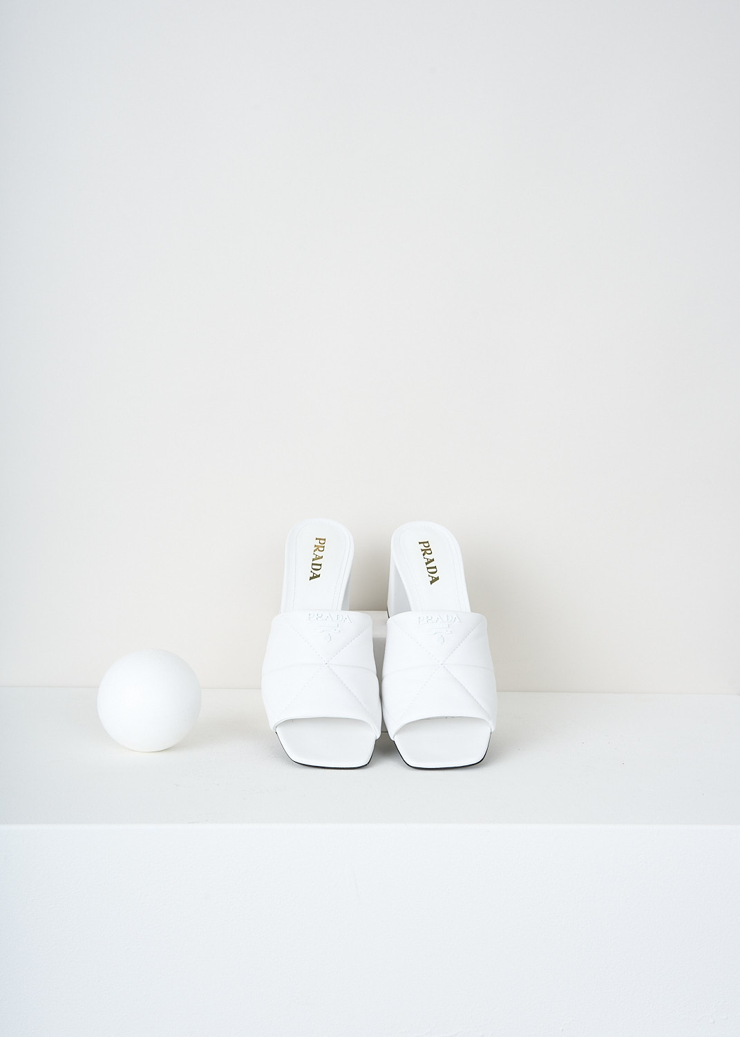 Prada, White matelassé mules, 038_NAPPA_1XX583_F0009_BIANCO, White, Top, These white open-toe mules have a broad matelassé strap across the vamp. These mules have a blocked heel.

