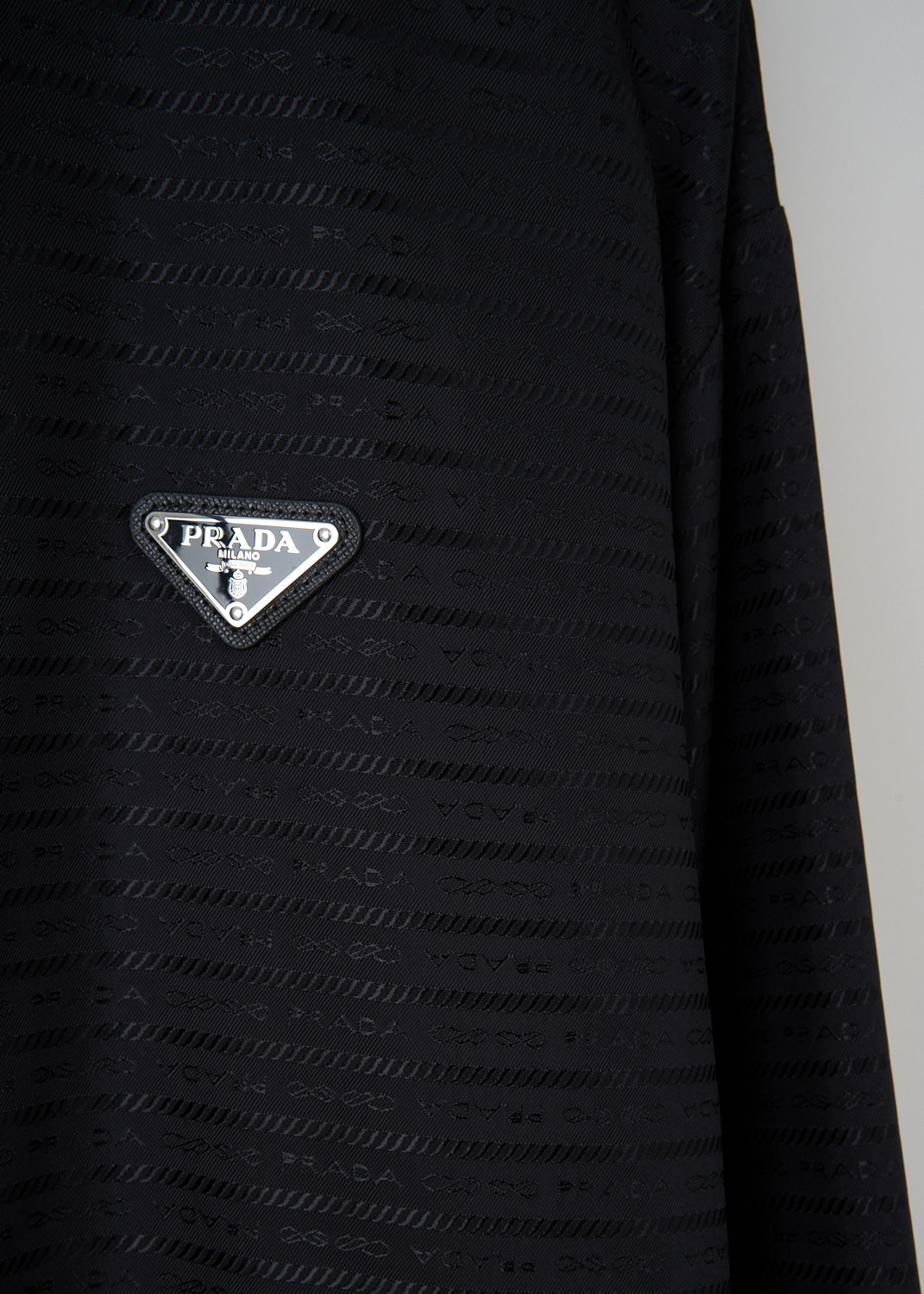 Black Re-Nylon jacket by Prada detail showing triangular logo and drawstring hem available at Kiki's Stocksale in Maastricht