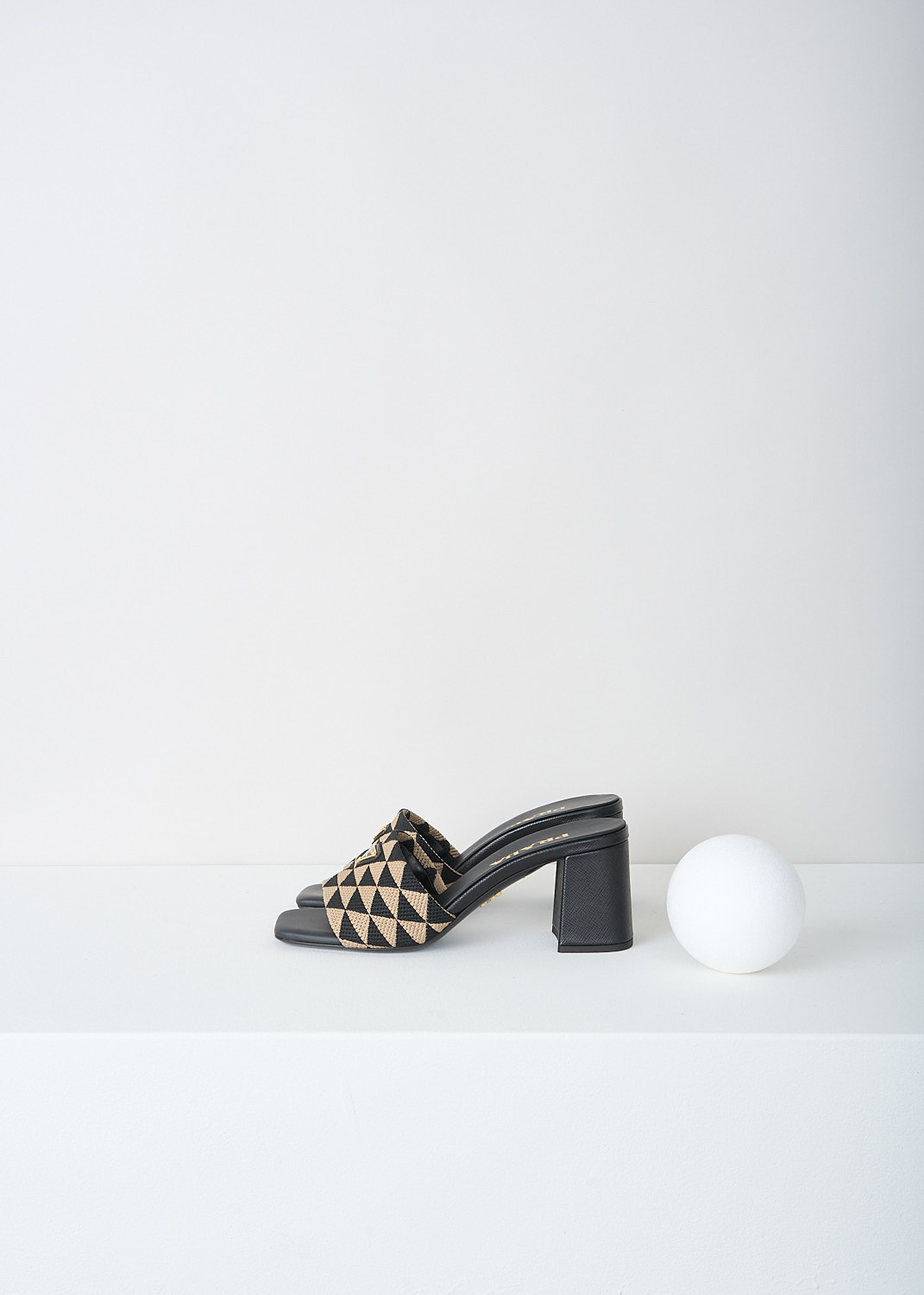 Prada, Black-and-beige triangolo mules, 3LK6_TRIANGOLO_JACQUARD_1XX637_F0Y30_NERO_CORDA_065, Black, Beige, Print, Side, These slip-on mules have a broad strap with a back-and-beige triangolo jacquard print. On the strap, the brand's triangle logo can be found in gold-tone metal. 
