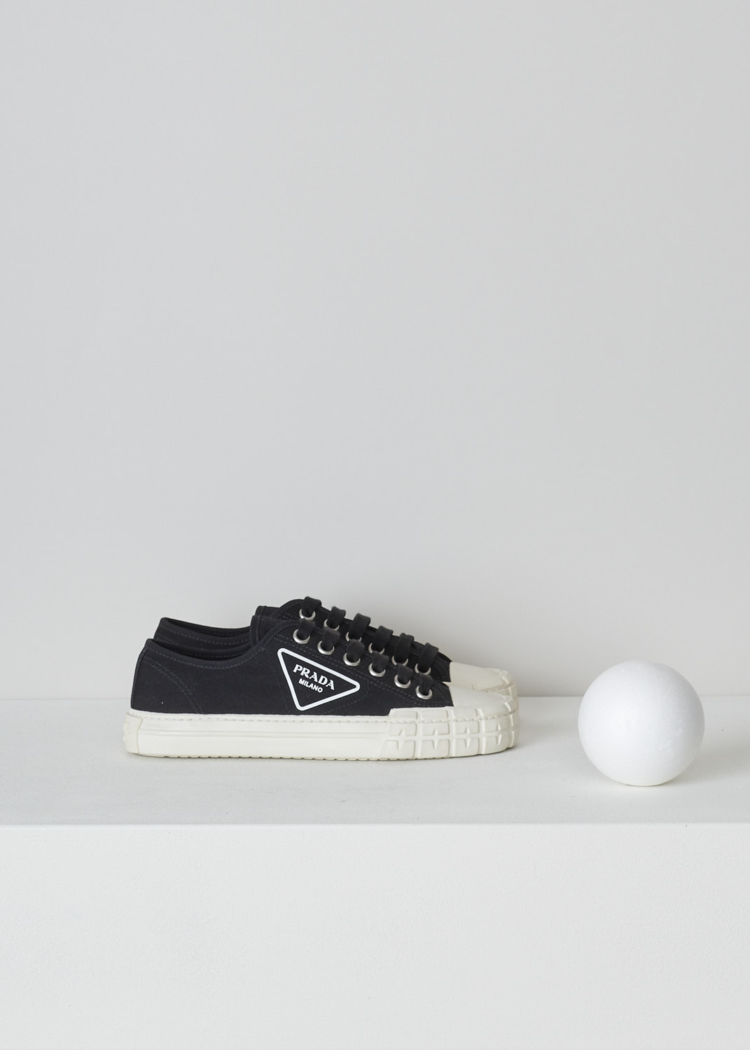 PRADA, LOW TOP BLACK CANVAS SNEAKERS, 1E231M_2OFZ_F057Z_NERO_AVORIO, Black, Side, These low top black canvas sneakers feature a front lace-up fastening with black laces. The brand's triangle logo can be found on the side in white rubber. These sneakers have a round toe with a white rubber toe cap and ribbed rubber soles.
