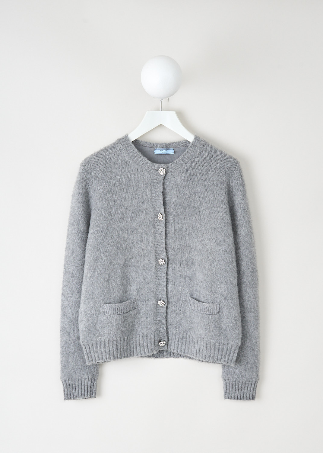 Prada light grey cardigan with round neckline, crystal button closure and ribbed trims at Kiki's Stocksale Maastricht designer outlet.