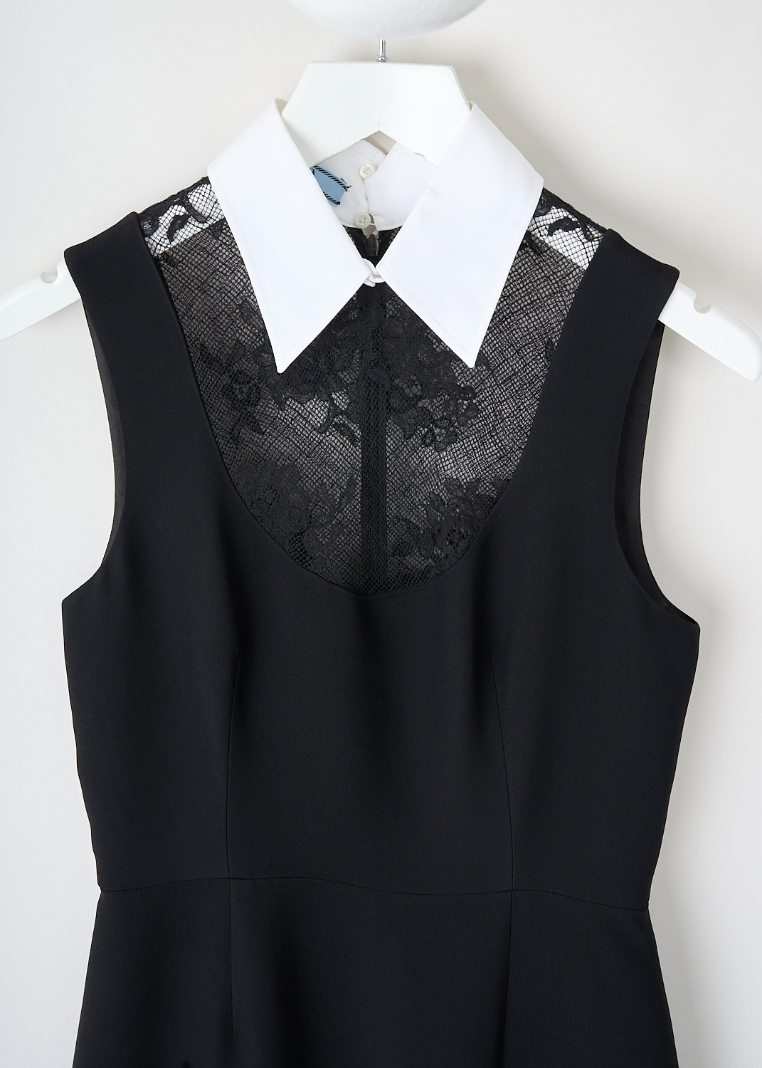 Close-up of lace inserts on chest area of Prada black maxi dress with white collar and refined contrast detailing.