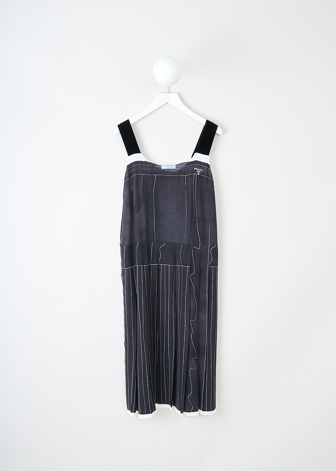 Prada, Black printed silk dress, 10R2_CREPEDECHINE_P3G58_F0002_NERO, Black, Front, This black silk dress has a printed white pattern of thin lines. The dress has broad velvet shoulder straps and a round neckline. On the front, the brand's signature lettering logo van be found. A concealed side zip functions as the closure. The dress has a dropped-waist silhouette. 
