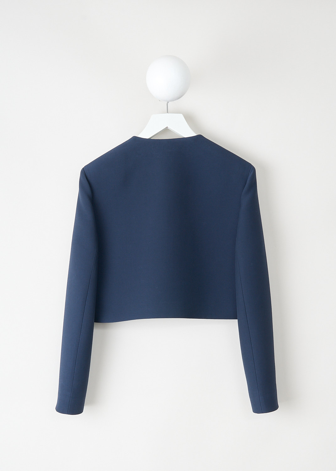 Back view of cropped midnight blue tailored jacket with clean silhouette and structured hemline.
