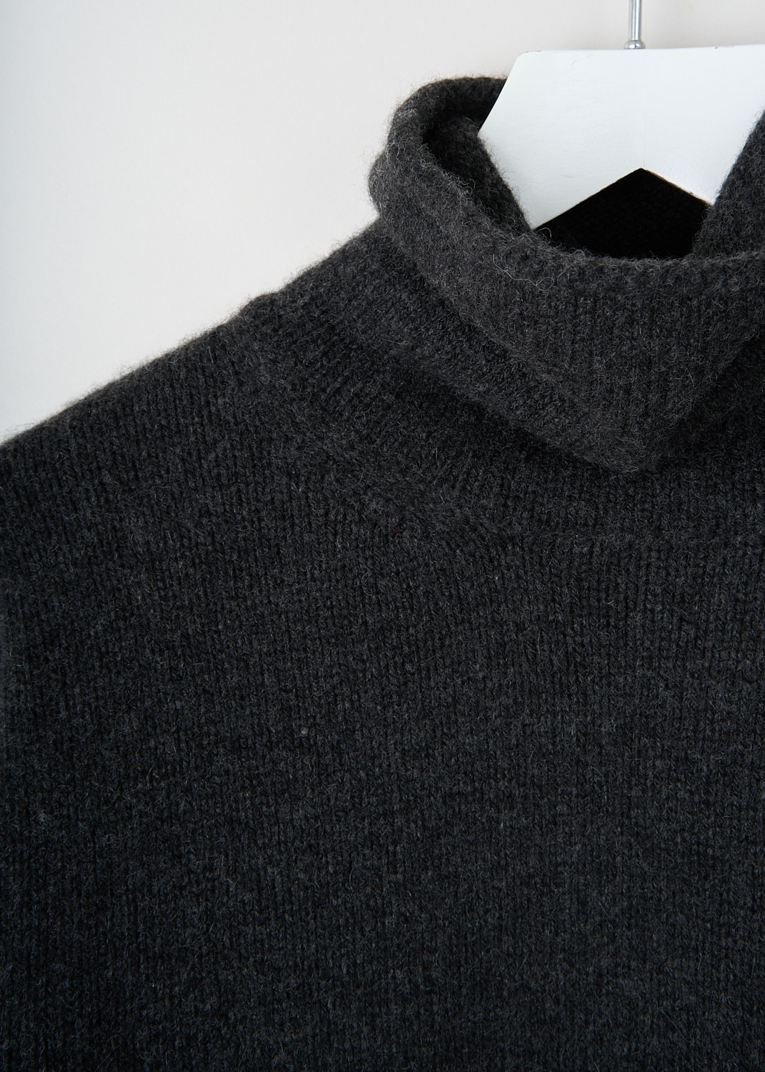 Close-up of soft charcoal cashmere knit with ribbed cuff detail on Pringle of Scotland sweater at Kiki's Stocksale Maastricht designer outlet.