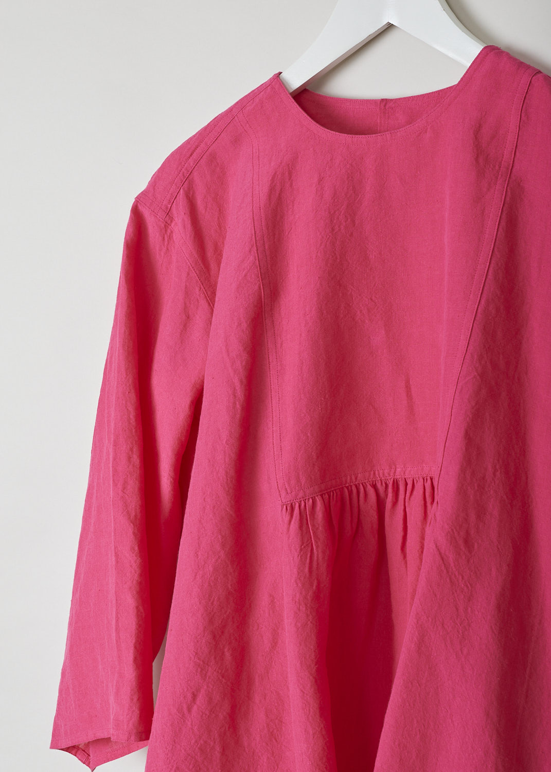 SOFIE D�HOORE, FUCHSIA COLORED BINETTE TOP, BINETTE_LIFE_FUCHSIA, Pink, Detail, This oversized fuchsia top features a round neckline, dropped shoulders and long sleeves. The A-line top has a square bib-like front with pleated details below. Concealed in the side seams, slanted pockets can be found. The top has an asymmetrical finish, meaning the back is a little longer than the front. 

