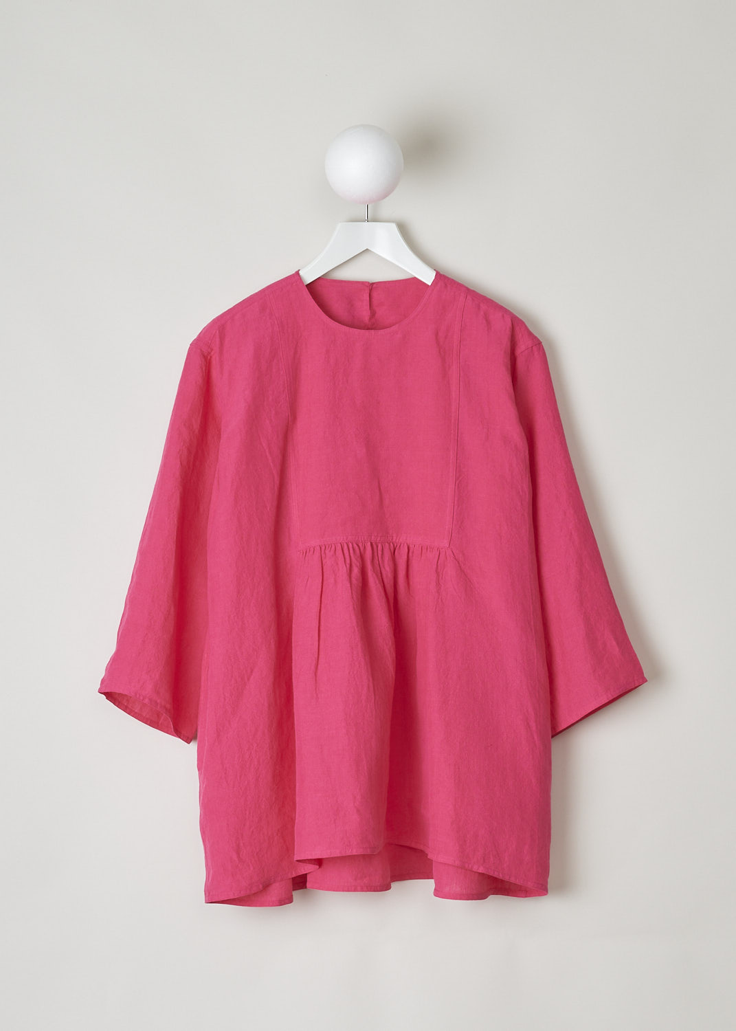 SOFIE Dâ€™HOORE, FUCHSIA COLORED BINETTE TOP, BINETTE_LIFE_FUCHSIA, Pink, Front, This oversized fuchsia top features a round neckline, dropped shoulders and long sleeves. The A-line top has a square bib-like front with pleated details below. Concealed in the side seams, slanted pockets can be found. The top has an asymmetrical finish, meaning the back is a little longer than the front. 

