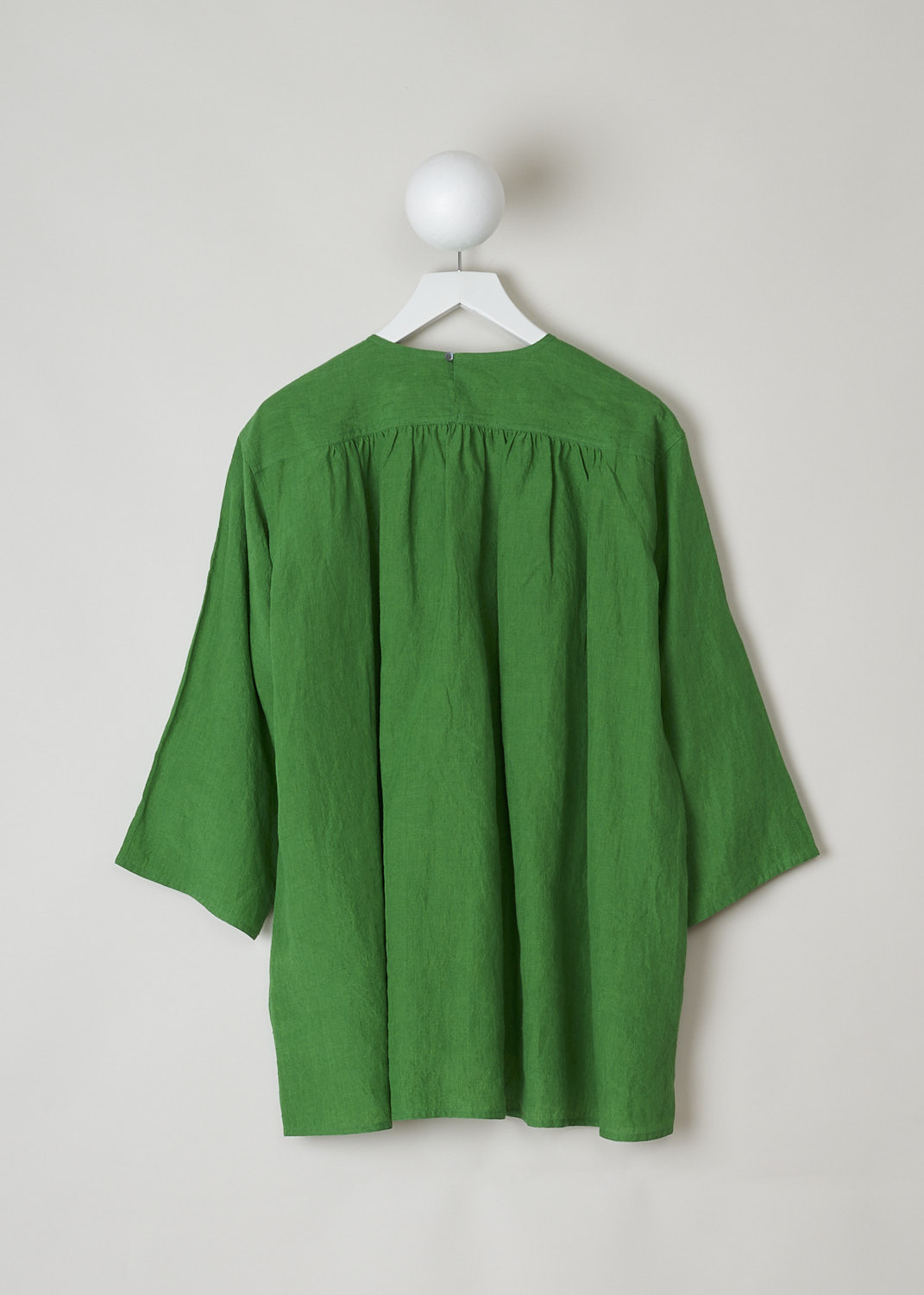 SOFIE D'HOORE, BRIGHT GREEN BINETTE TOP, BINETTE_LIFE_GRASS, Green, Back, This oversized bright green top features a round neckline, dropped shoulders and long sleeves. The A-line top has a square bib-like front with pleated details below. Concealed in the side seams, slanted pockets can be found. The top has an asymmetrical finish, meaning the back is a little longer than the front. 


