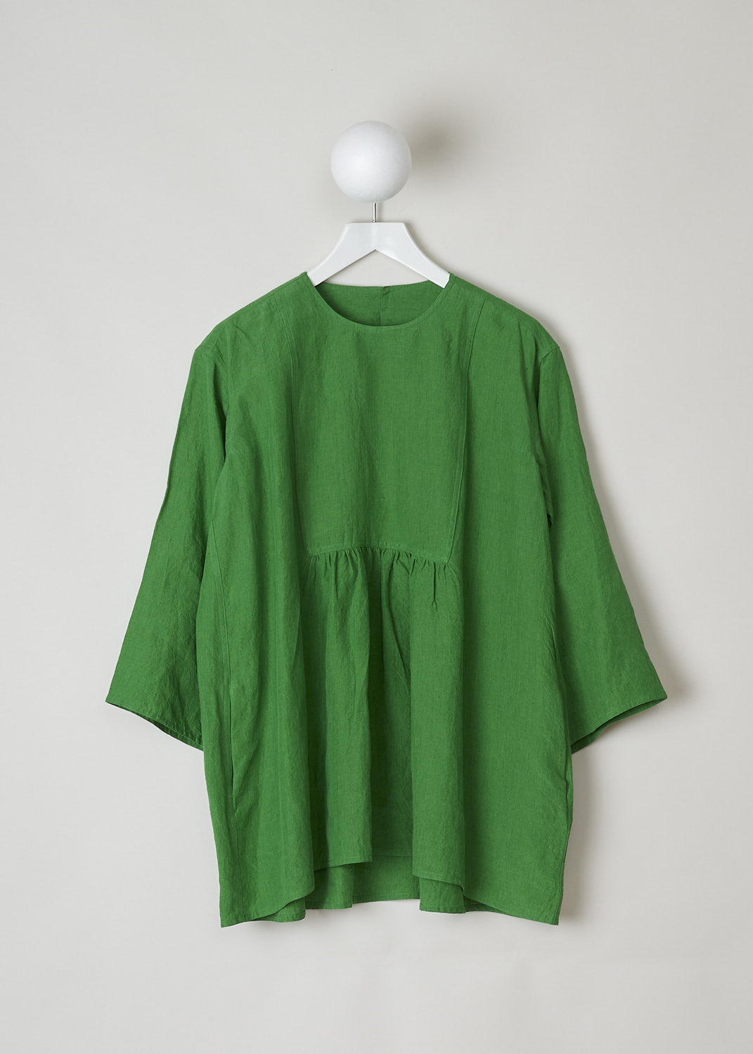 SOFIE D'HOORE, BRIGHT GREEN BINETTE TOP, BINETTE_LIFE_GRASS, Green, Front, This oversized bright green top features a round neckline, dropped shoulders and long sleeves. The A-line top has a square bib-like front with pleated details below. Concealed in the side seams, slanted pockets can be found. The top has an asymmetrical finish, meaning the back is a little longer than the front. 

