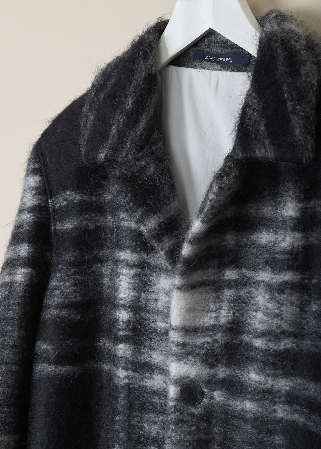 SOFIE Dâ€™HOORE, LONG BLACK AND WHITE TARTAN CAY COAT, CAY_WOMO_BLACK_TARTAN, Black, White, Print, Detail, This long black and white tartan Cay coat has a spread collar and a front button closure. The long sleeves have slightly dropped shoulders and a raw edged cuff. In the front, the coat has on-seam slanted pockets. The coat has a straight raw edged hemline. The coat is fully lined and has a single inner pocket. 

